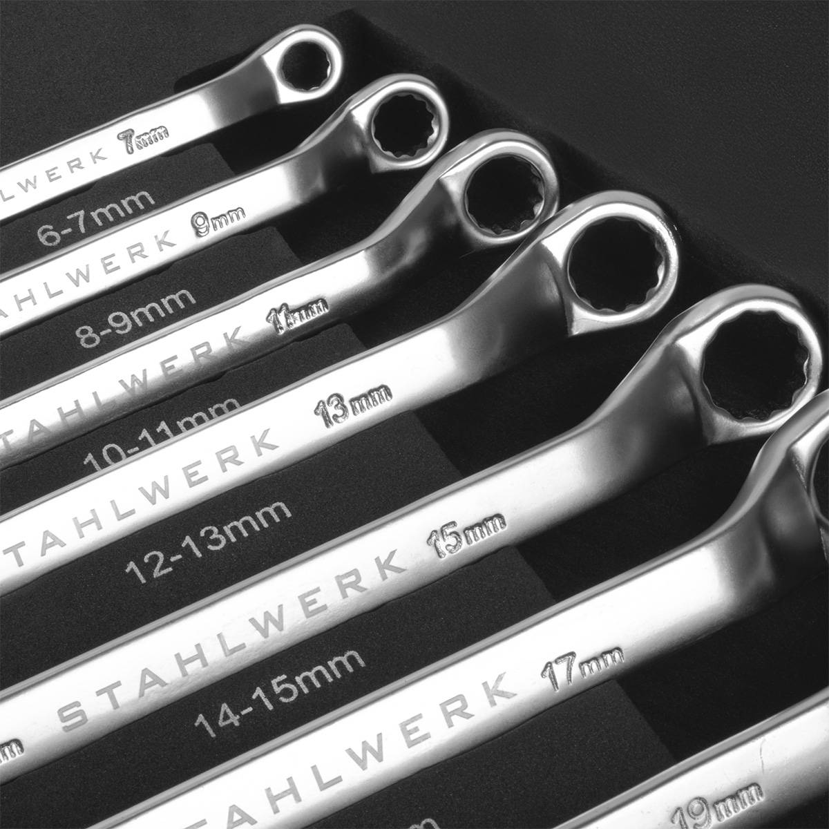 Eine Reihe von Stahlwerk-Schraubenschlüsseln, sortiert nach Größe und von 6-7 mm bis 17-19 mm reichend, präsentiert ihren glänzenden metallischen Finish.