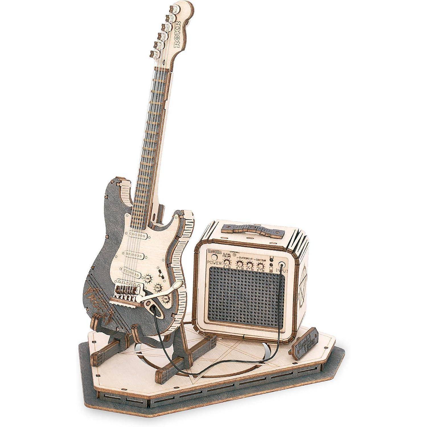 Ein Holzmodell einer E-Gitarre mit einem Verstärker auf einem Sockel. Die Gitarre ist mit detaillierten Ausschnitten verziert, und der Amp verfügt über Regler und Schalter.