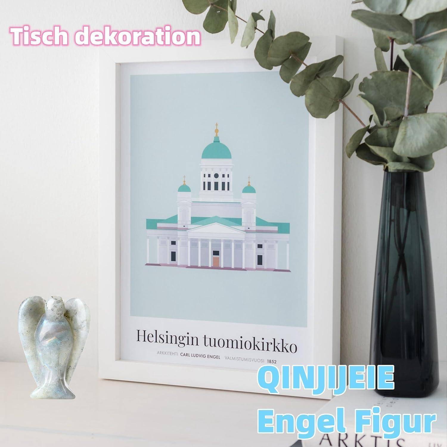 Ein Foto von einer gerahmten Illustration des Helsinkier Doms auf einem Regal, neben einer kleinen Engelstatue und einer Vase mit Grünpflanzen.