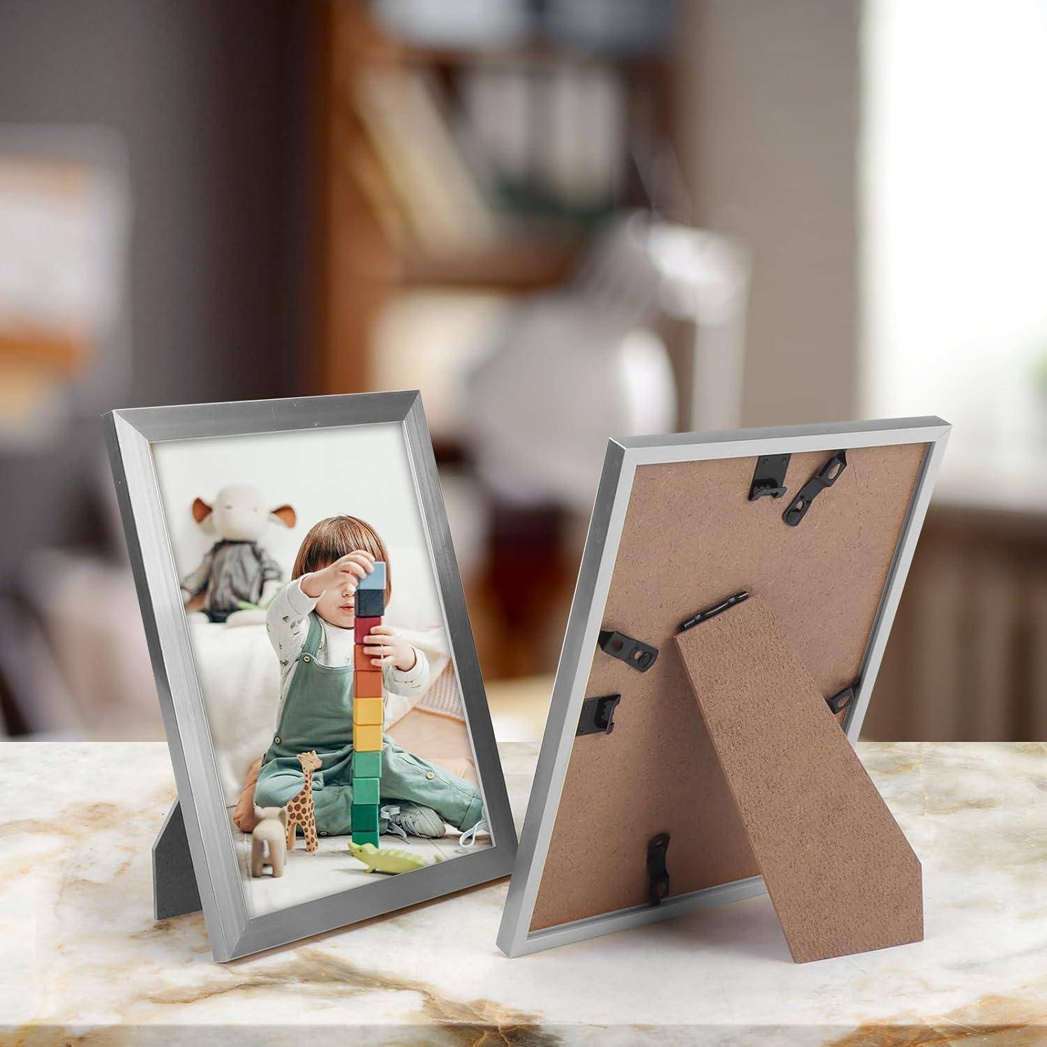 Ein gerahmtes Foto auf einem Tisch, das ein Kind zeigt, das mit bunten Stapelblöcken spielt, mit einem unscharfen Wohnungsinterieur im Hintergrund.