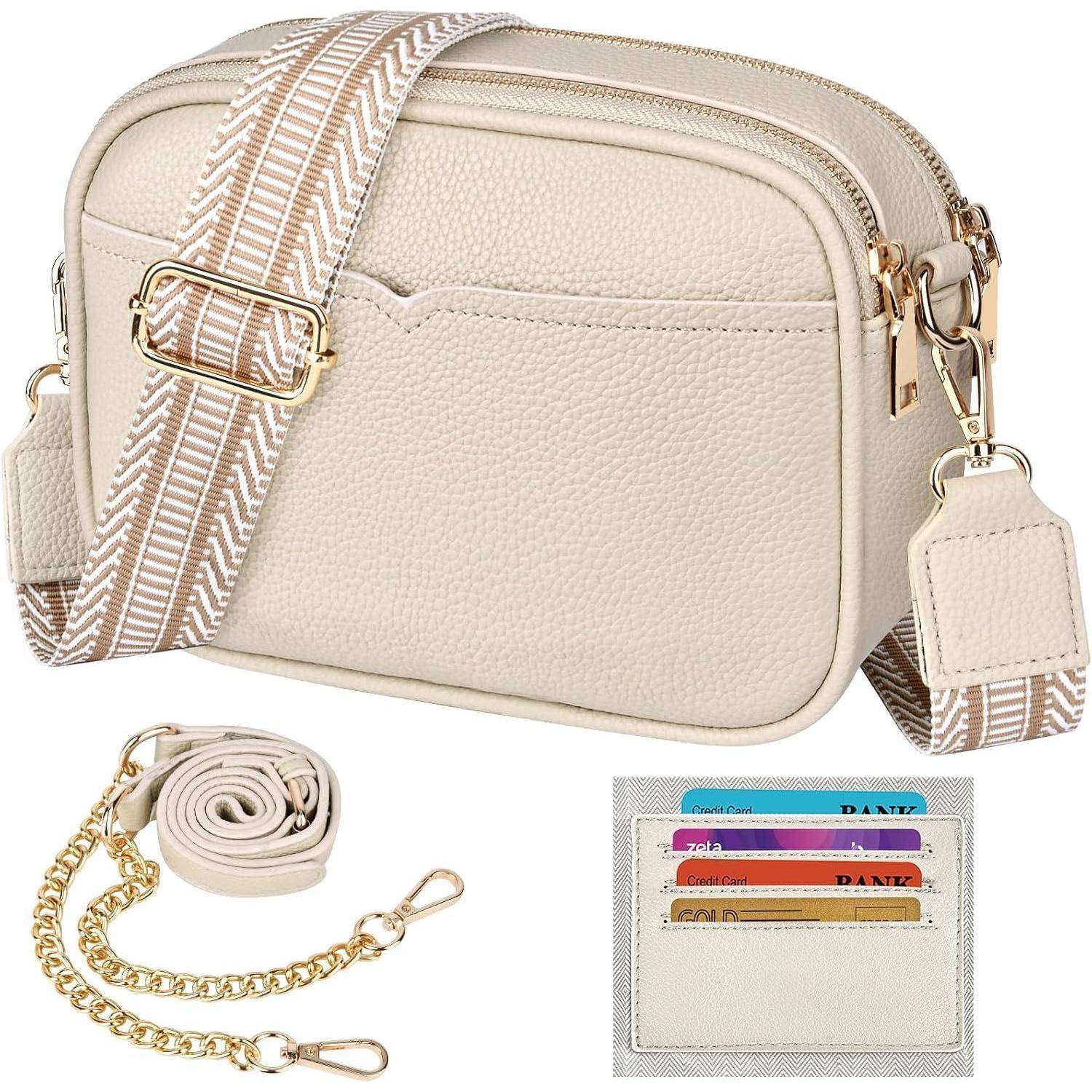 Eine beige Umhängetasche mit strukturierter Oberfläche, goldener Beschlägen, Reißverschluss-Verschluss und einem Träger mit Zickzack-Muster. Enthält einen zusätzlichen Kettengurt und einen Kartenhalter mit drei sichtbaren Karten.
