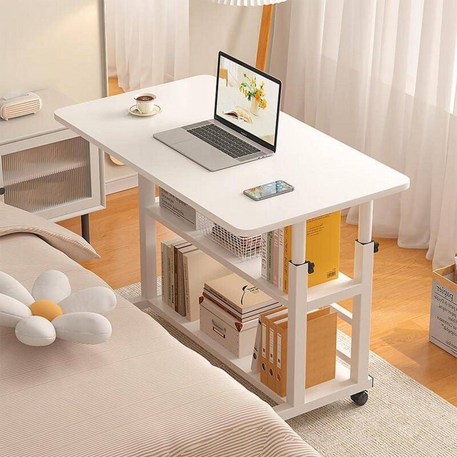 Ein aufgeräumtes Home Office mit einem Laptop auf einem weißen Schreibtisch; darunter befinden sich Regale mit Büchern und Dekorationen. Heller Raum mit natürlichem Licht von einem Fenster.