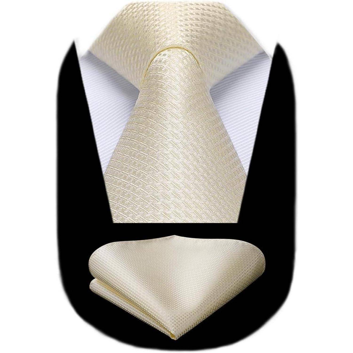 Eine cremefarbene gemusterte Krawatte und das passende Einstecktuch werden vor einem schwarzen Hintergrund präsentiert. Die Krawatte ist ordentlich geknotet und zeigt eine Karomuster-Textur.