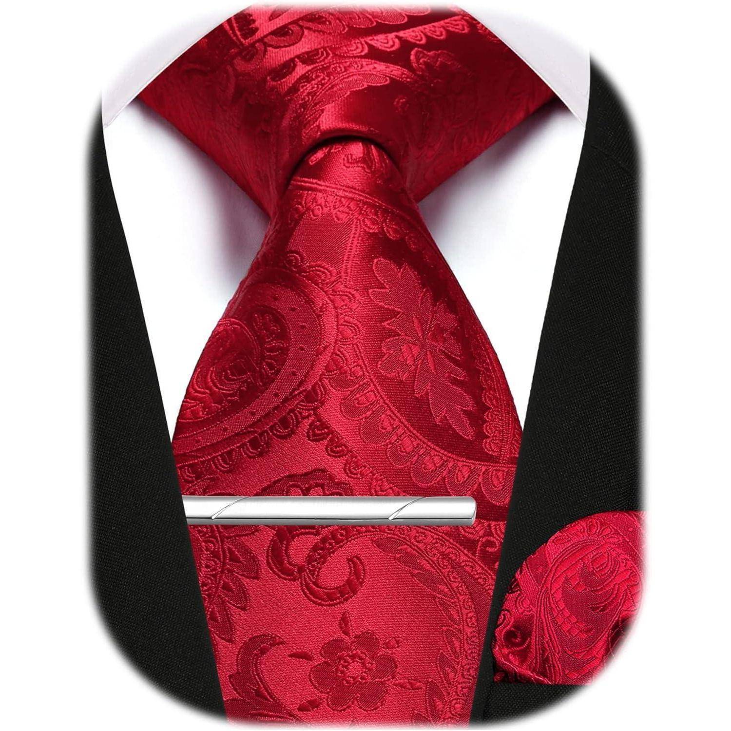 Eine rote Paisley-Krawatte mit einem passenden Einstecktuch auf einem weißen Hemd und einer schwarzen Anzugjacke, mit einer silbernen Krawattennadel.