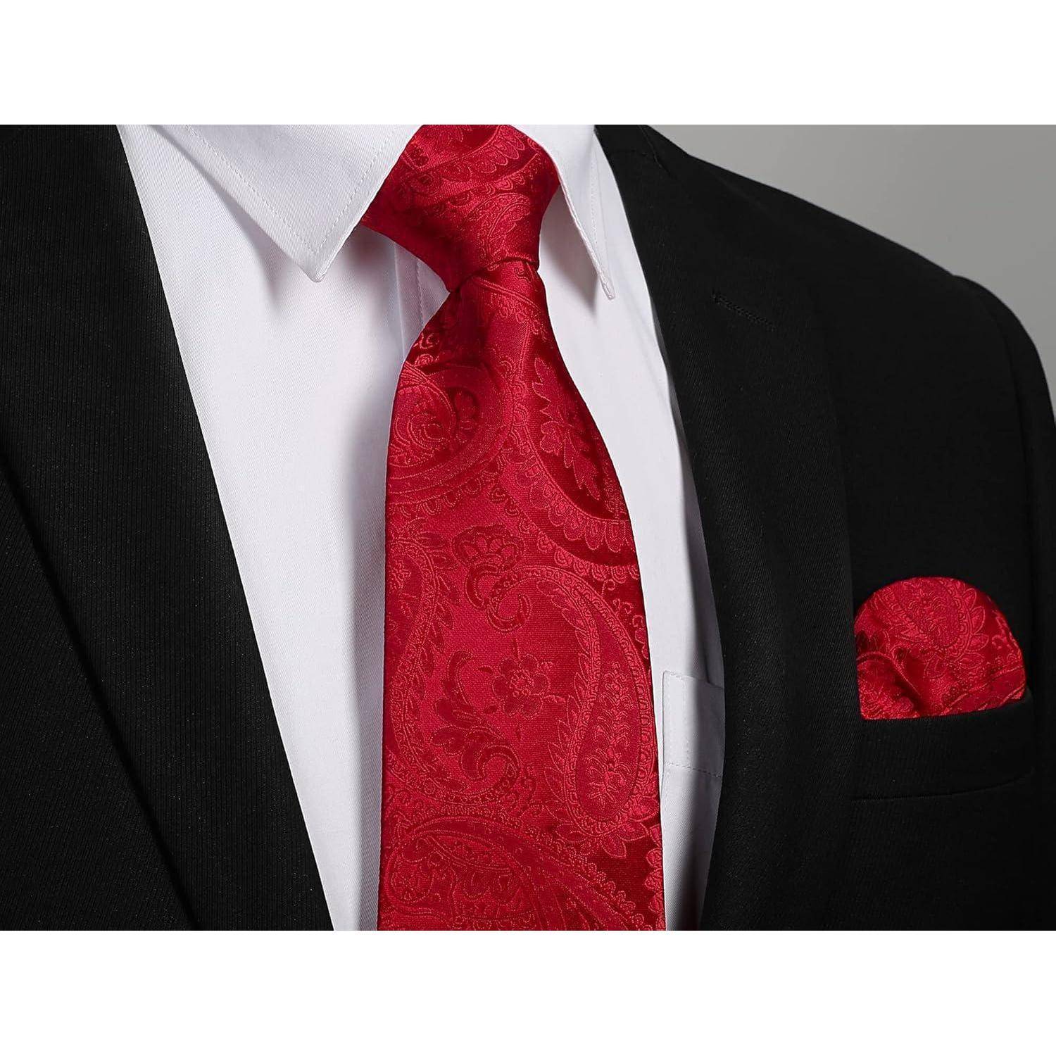 Eine Nahaufnahme einer Person, die einen schwarzen Anzug, ein weißes Hemd und eine rot-paisley gemusterte Krawatte mit einem passenden roten Einstecktuch trägt.