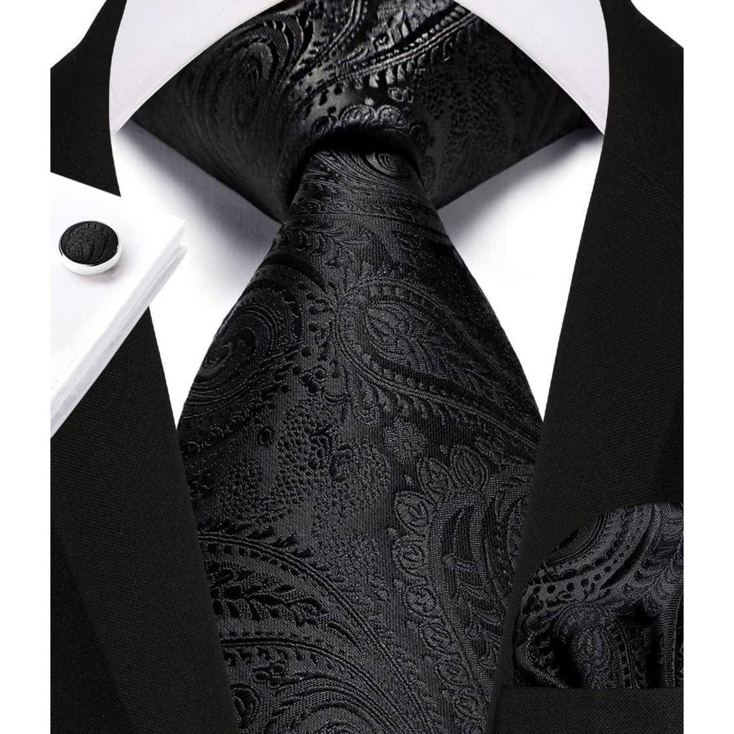 Eine Nahaufnahme eines eleganten schwarzen Anzugs mit einer Paisley-gemusterten Krawatte und passendem Einstecktuch, die eine elegante und sophistizierte Mode betont.