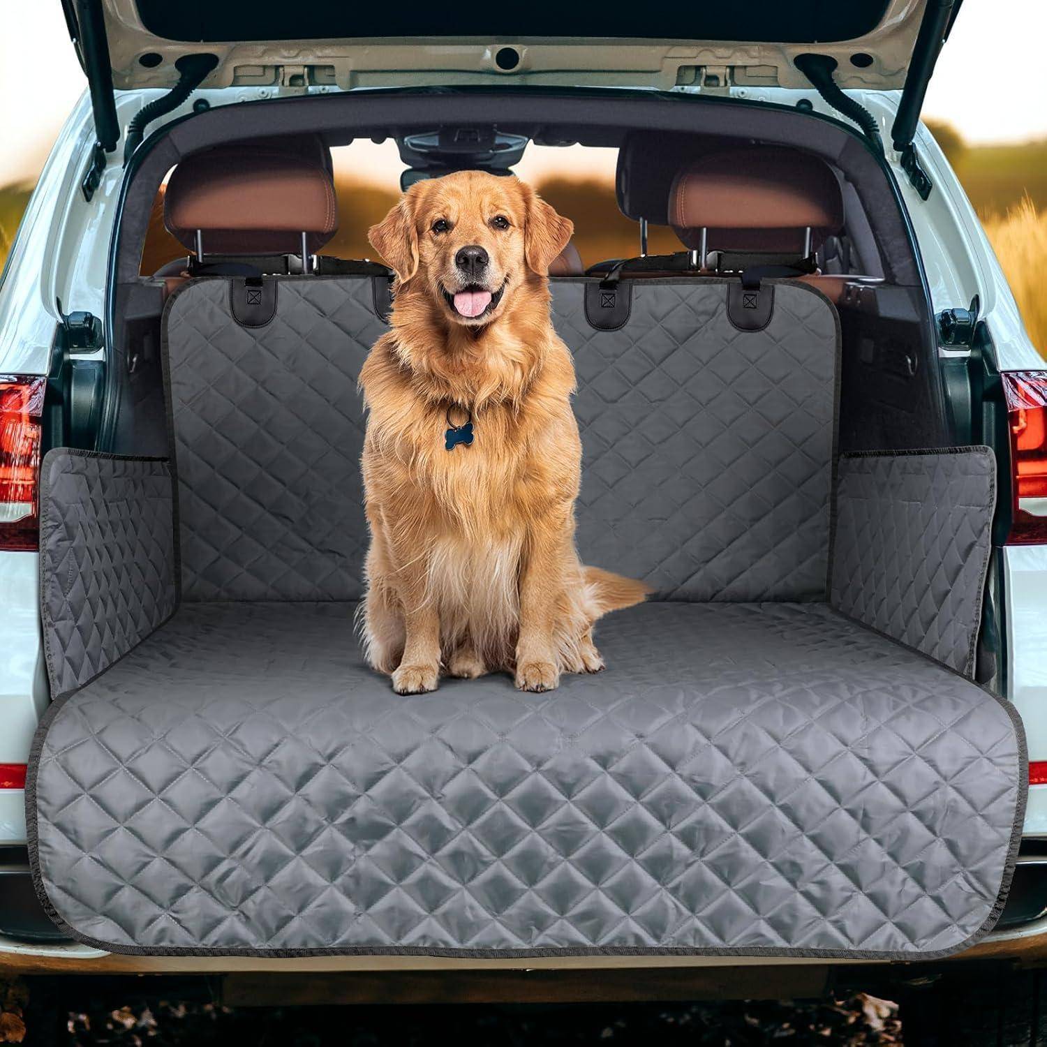 Ein Golden Retriever sitzt auf einer gesteppten grauen Schutzdecke im Heck eines Autos und blickt direkt in die Kamera mit einem glücklichen Gesichtsausdruck.