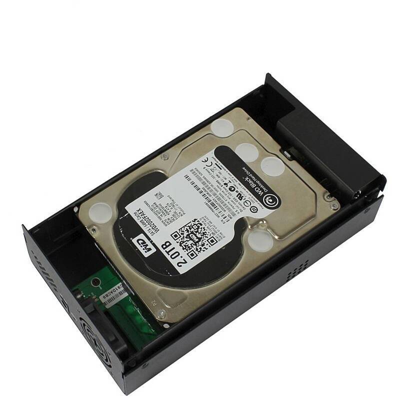 Eine Festplatte ist in einem schwarzen externen Gehäuse montiert, mit sichtbaren Anschlüssen und Leiterplatte. Die Oberseite der Festplatte zeigt eine Etikette mit Logos und Informationen.