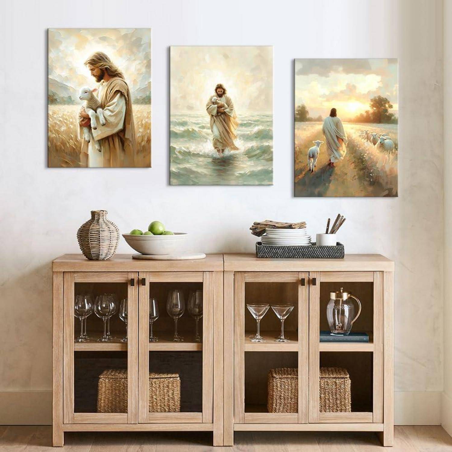 Drei Gemälde einer spirituellen Figur: ein Lamm auf einer Wiese haltend, auf Wasser gehend und bei Sonnenuntergang eine Schafherde hütend. Darunter ein Holzschrank mit Dekorationsgegenständen.