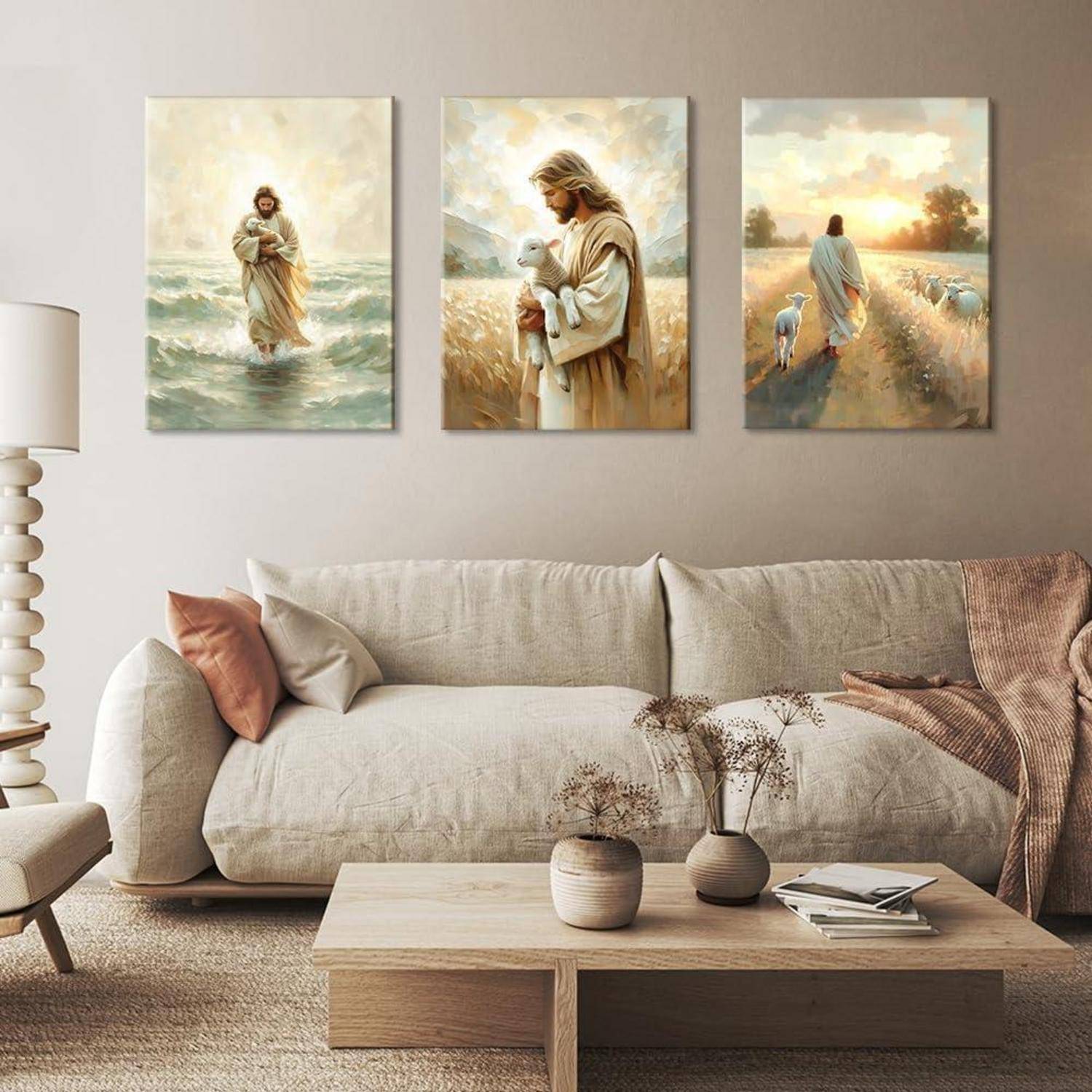 Gemälde einer Figur, die auf Wasser wandelt, ein Lamm auf einem Feld trägt und bei Sonnenuntergang mit Schafen geht, sind über einem Sofa ausgestellt.