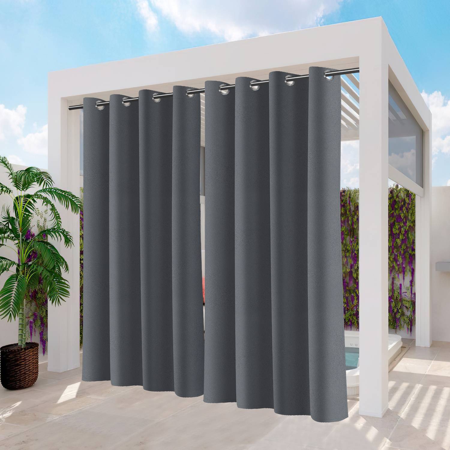 Graue Outdoor-Vorhänge hängen von einem modernen weißen Pergola und umschließen teilweise eine Terrassenfläche mit einer Pflanze und einem Blick auf Grünflächen.