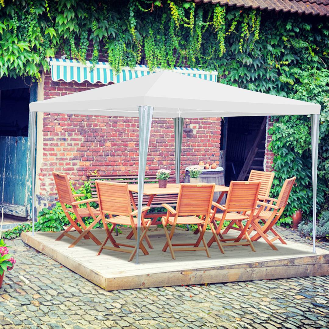 Eine Holzterrasse mit einem weißen Baldachin, umgeben von Grün, mit einem Tisch und sechs Stühlen vor einer Ziegelkulisse, die einen einladenden Außenbereich schafft.