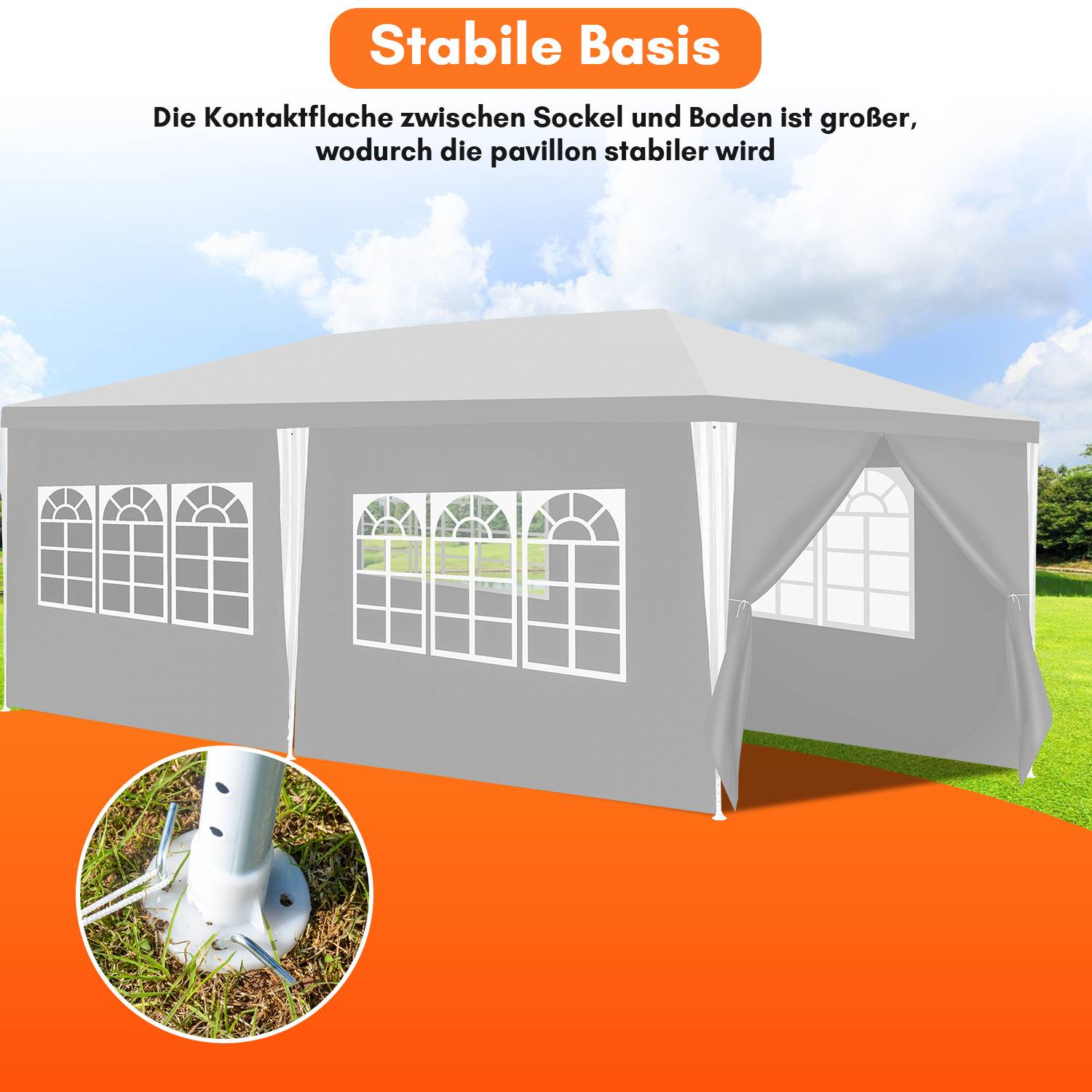 Ein großes graues Pavillonzelt mit Bogenfenstern ist auf einem grasbedeckten Feld unter klarem Himmel aufgestellt. Eingesetzt ist eine gesicherte Metallbasis.