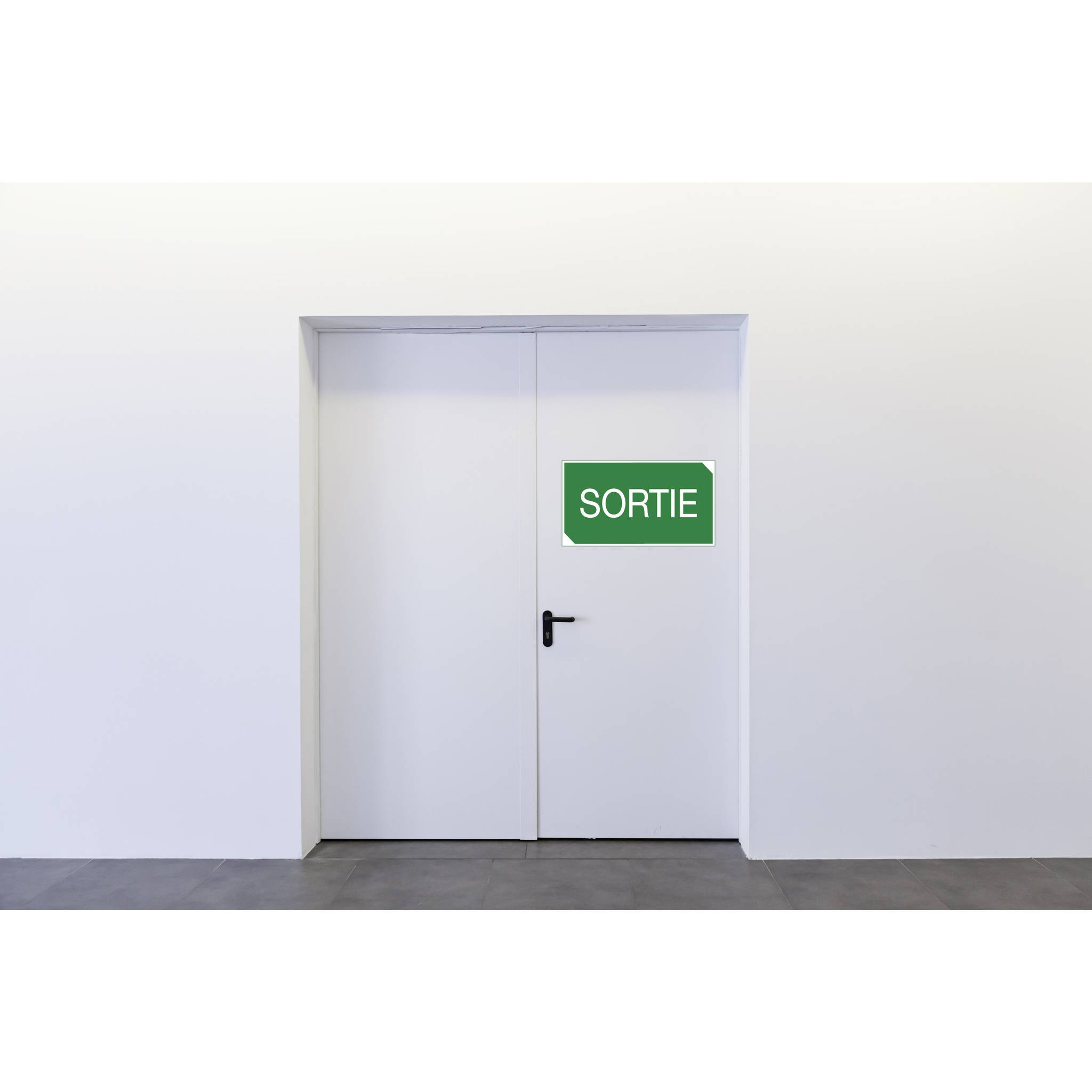 Eine weiße Tür mit einem grünen Schild, auf dem 