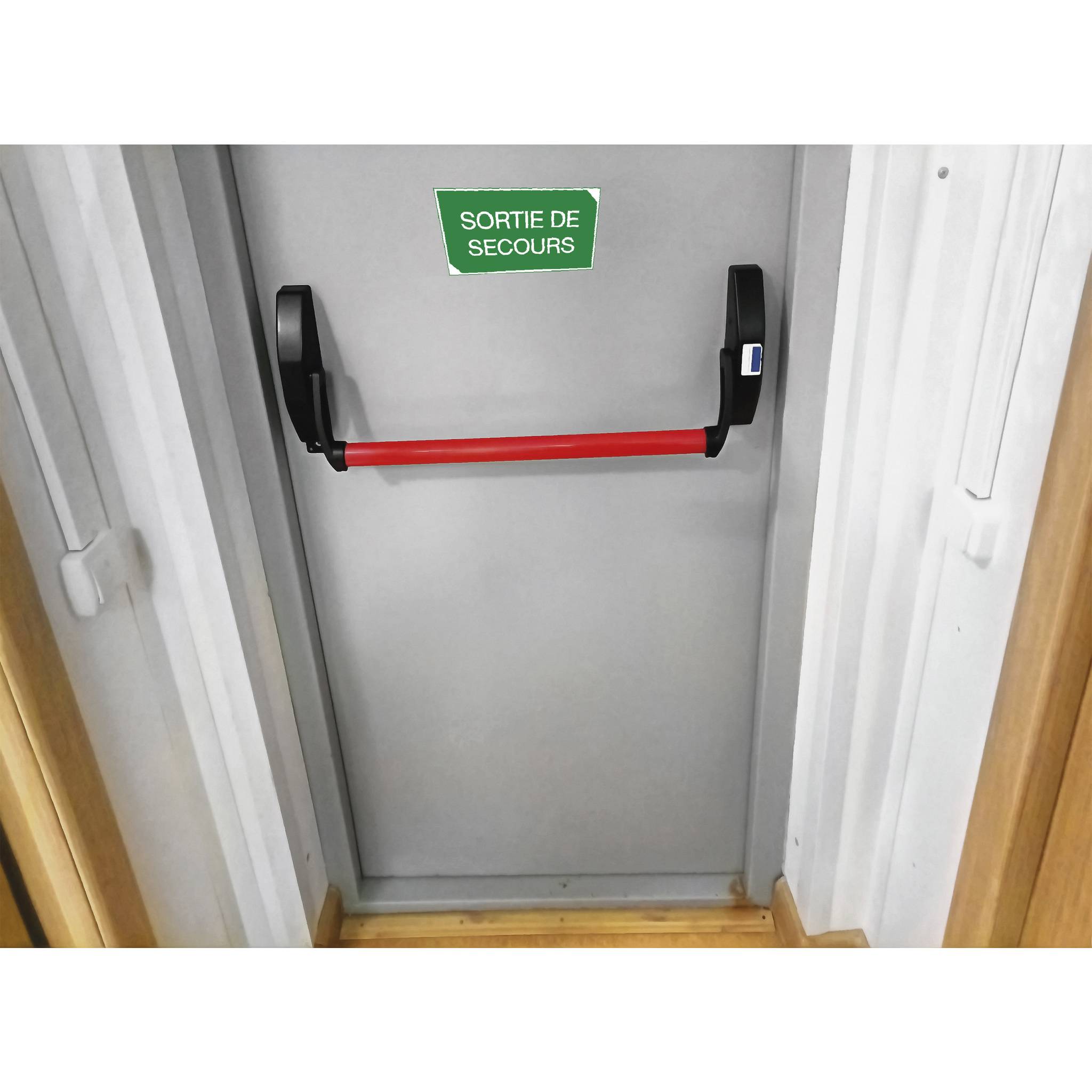 Notausgang mit einer roten Druckstange und einem Schild darüber mit der Aufschrift ‚Notausgang' auf Französisch.