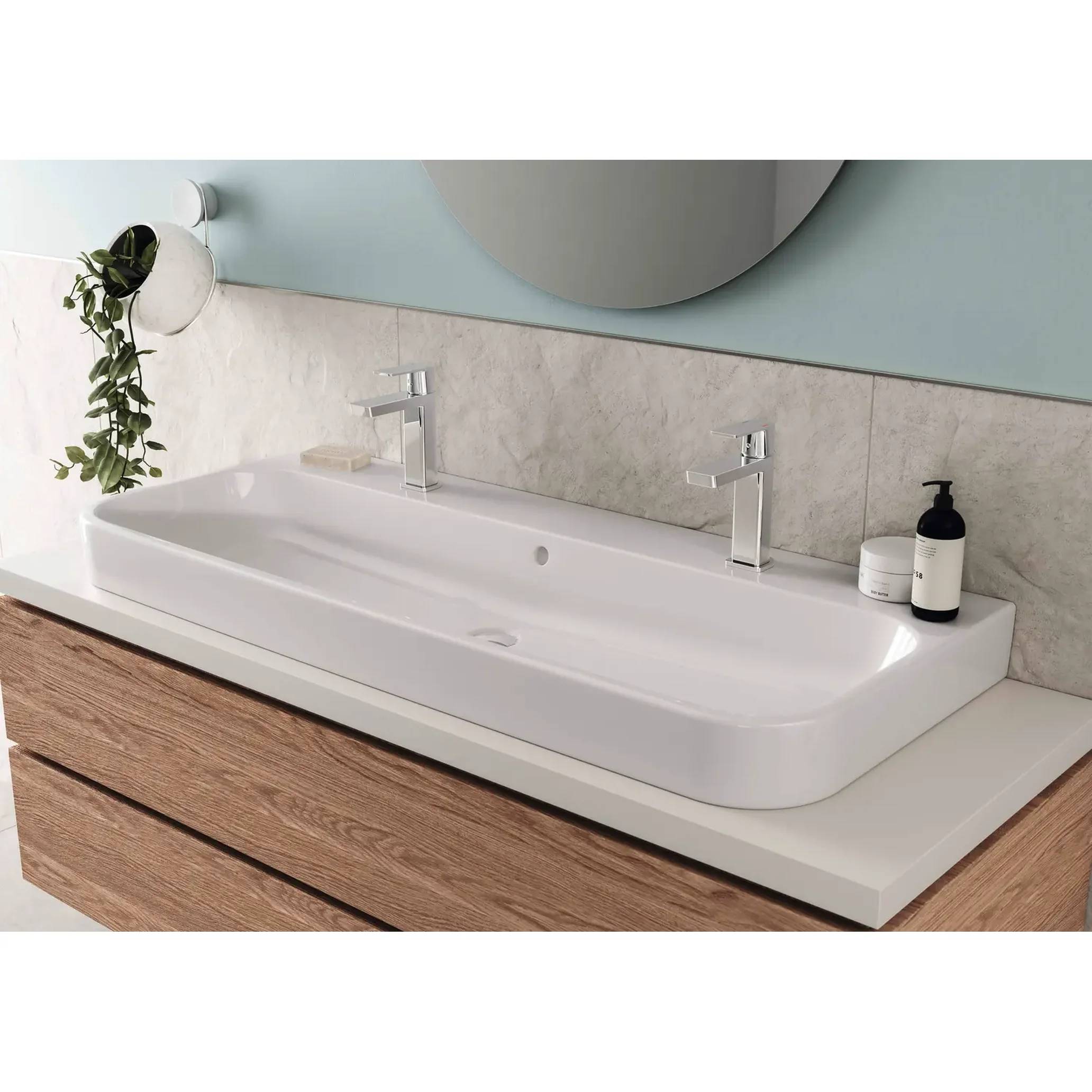 Modernes Badezimmer-Waschtisch mit weißem Doppelwaschbecken, wandmontiertem Wasserhahn, rundem Spiegel und Holzschrank darunter