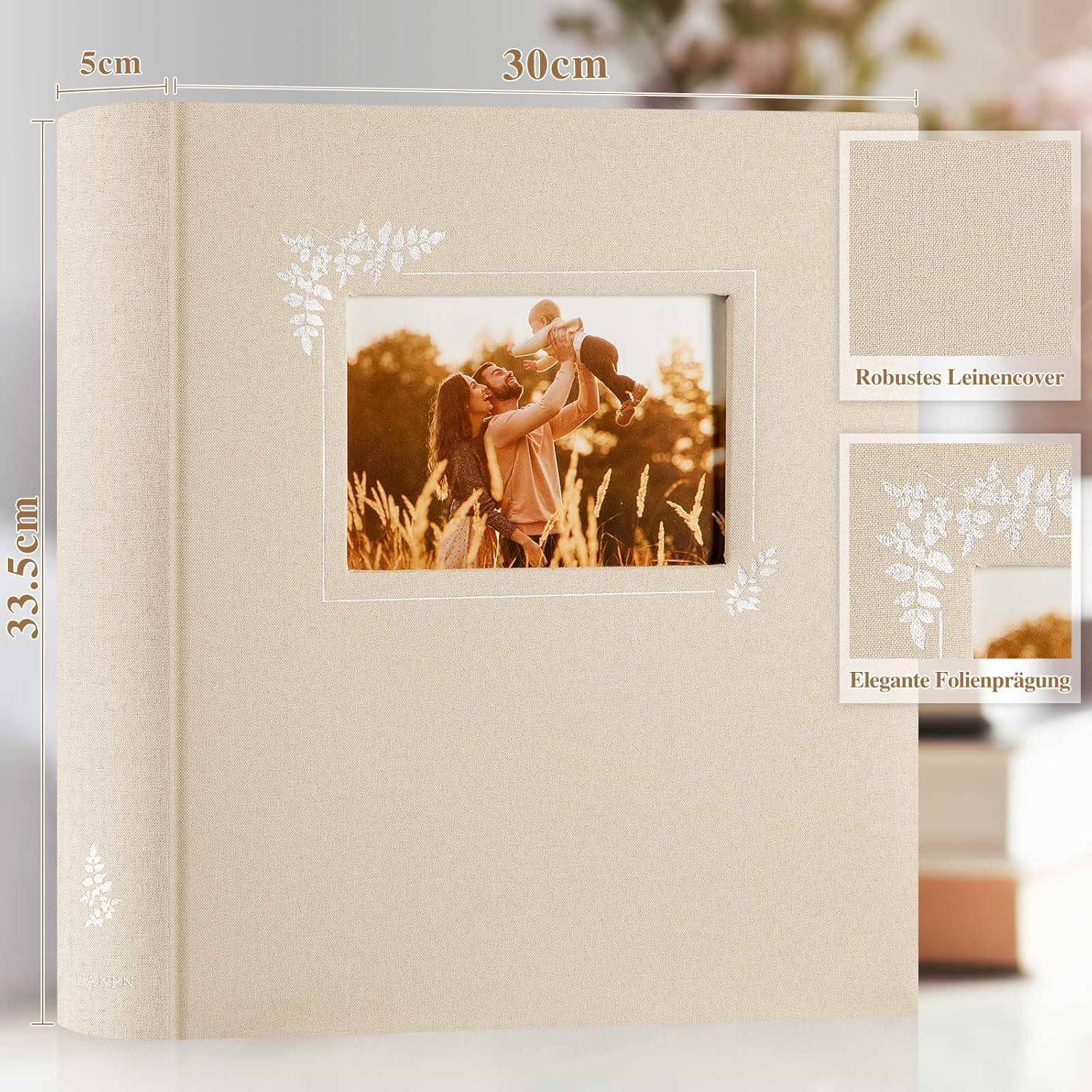 Ein beige Fotoalbum mit Blattdesigns, das ein zentrales Bild eines Elternteils zeigt, der ein Kind auf einem Feld hochhebt. Abmessungen: 30 cm x 33,5 cm x 5 cm.