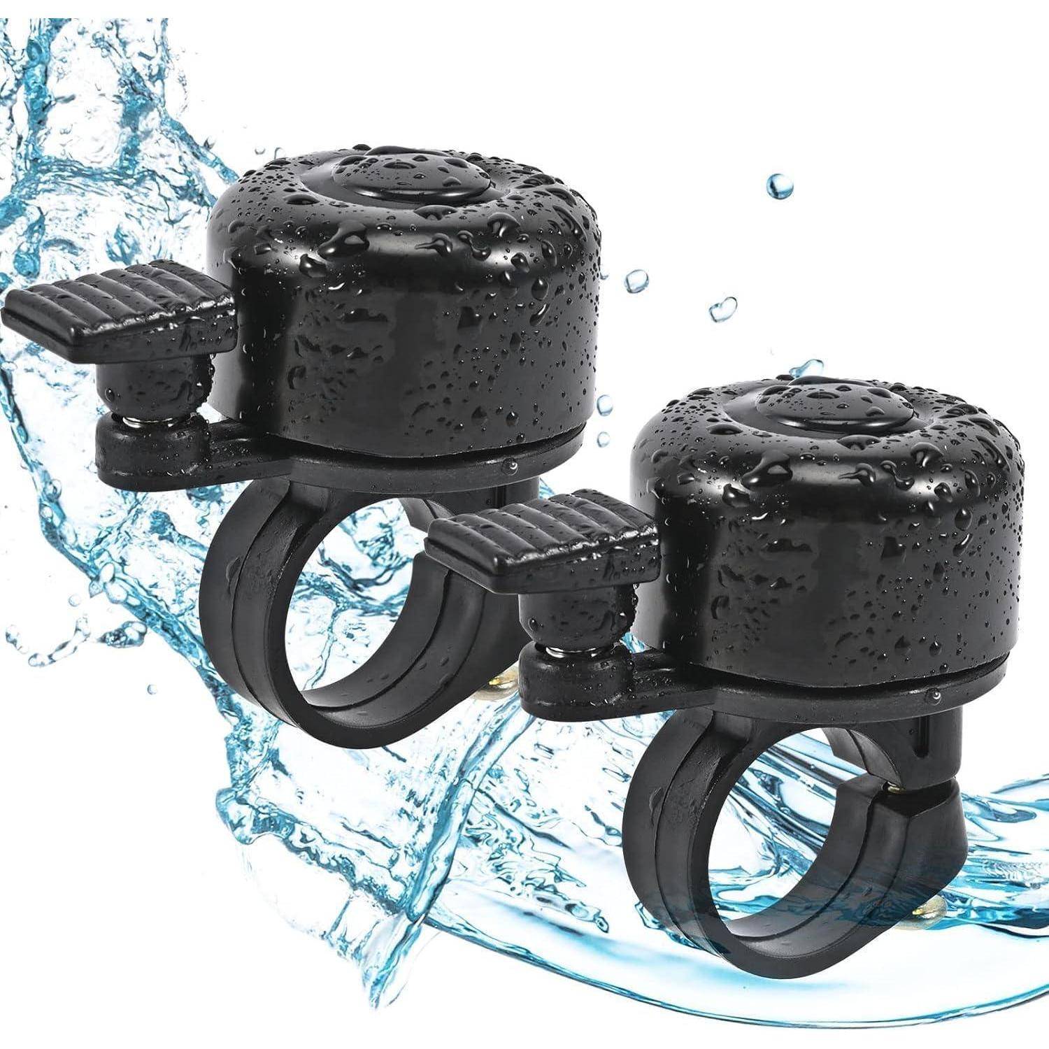 Zwei schwarze Fahrradklingeln mit Wassertropfen, die eine wasserdichte Eigenschaft andeuten, sind an einem Lenker vor einem Spritzenhintergrund befestigt.