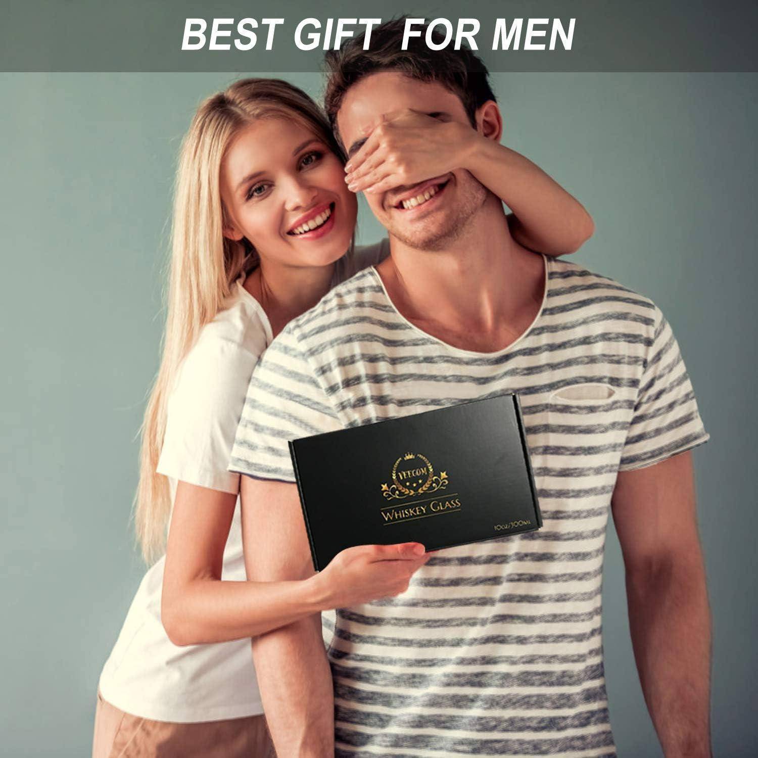 Eine Frau deckt einem Mann spielerisch die Augen zu, während sie eine Geschenkbox mit der Aufschrift 