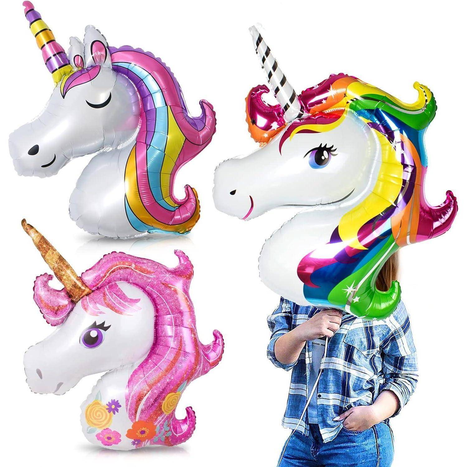 Drei Einhorn-Ballons mit lebendigen, regenbogenfarbenen Mähnen; eine Person hält einen, teilweise verdeckt, trägt ein Karohemd.