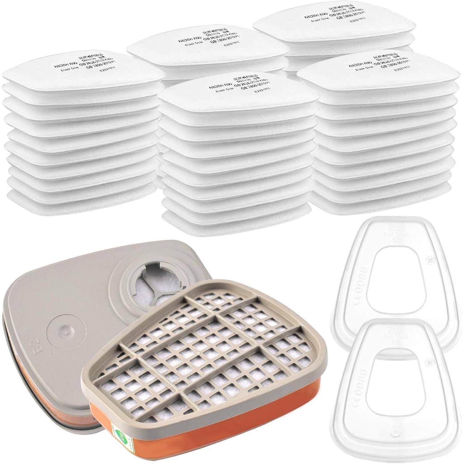 Eine Sammlung von weißen Luftfilterpads, beigen Kartuschen und transparenten Maskenschutzhüllen, die zur Luftfiltration und zum Atemschutz verwendet werden.