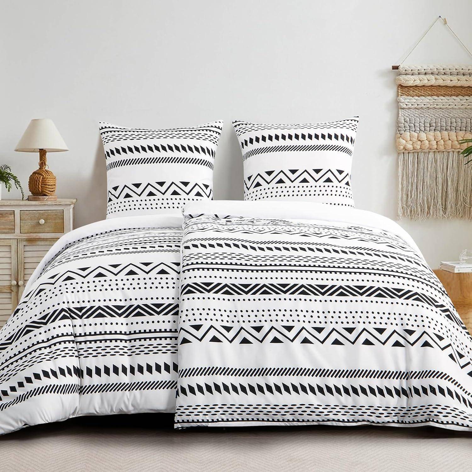 Ein ordentlich gemachtes Bett mit einer schwarz-weißen geometrisch gemusterten Bettdecke und passenden Kissen, neben einem Nachttisch mit einer Lampe und Dekorationselementen.