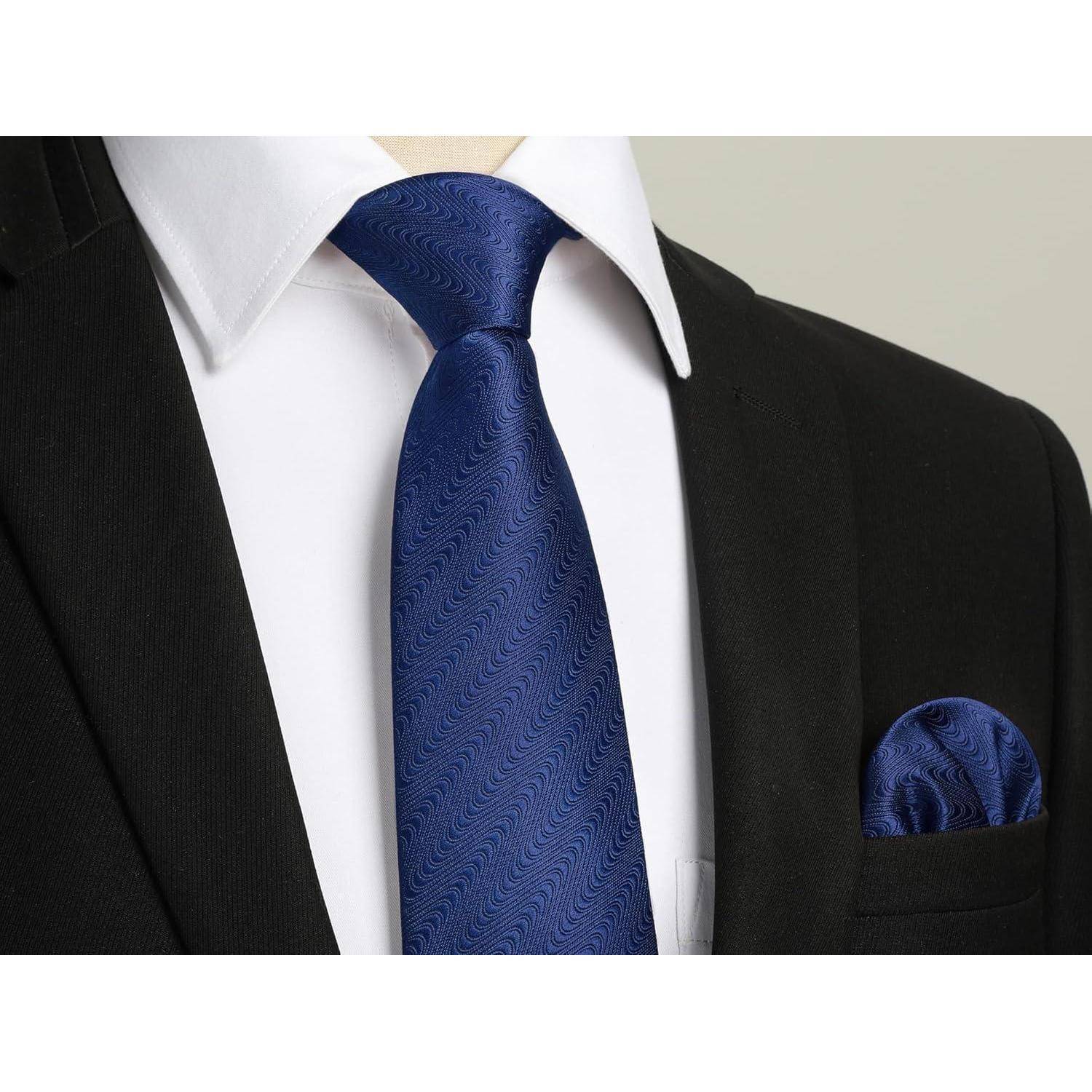 Eine Nahaufnahme einer Person, die einen dunklen Anzug mit einem weißen Hemd und einer blauen, gemusterten Krawatte trägt, mit einem passenden blauen Einstecktuch.