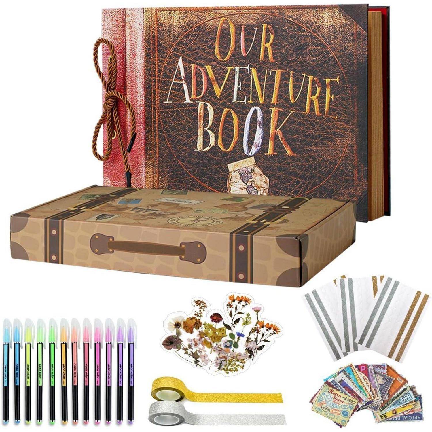 Unser 'Abenteuer-Buch' Scrapbook mit einem Vintage-Design, farbigen Stiften, dekorativen Stickern und Washi-Tape-Rollen umgeben eine Geschenkbox im Vintage-Stil.