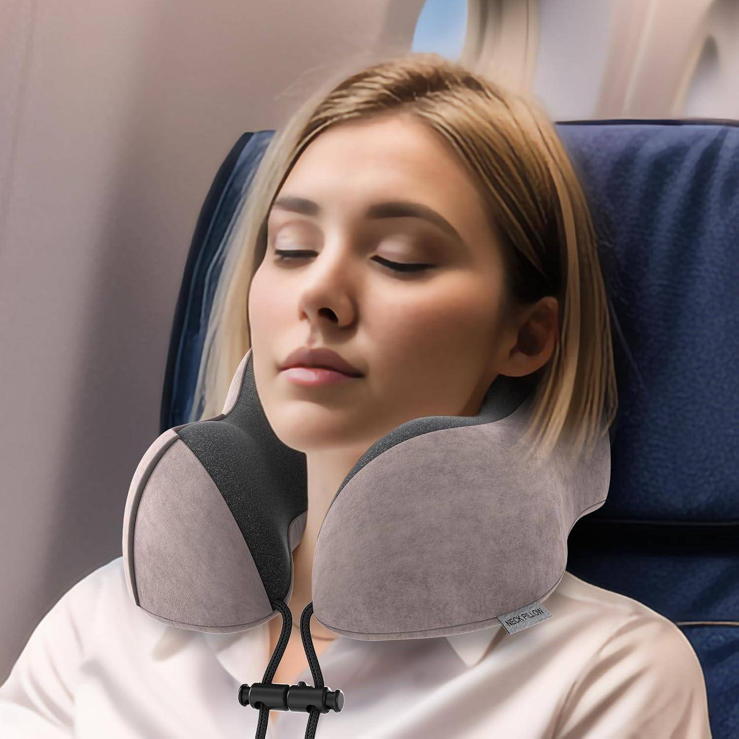 Eine Person schläft bequem mit einem grauen Nackenkissen auf einem Flugzeugsitz, was Entspannung während eines Fluges andeutet.