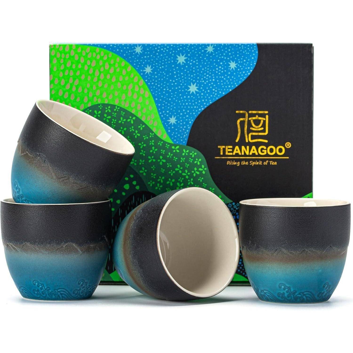 Fünf Keramik-Teekuppentassen mit einem eleganten Blau-Schwarz-Verlaufsdesign sind vor einer farbenfrohen 'Teanagoo'-Box mit Logo und abstrakter Kunst angeordnet.