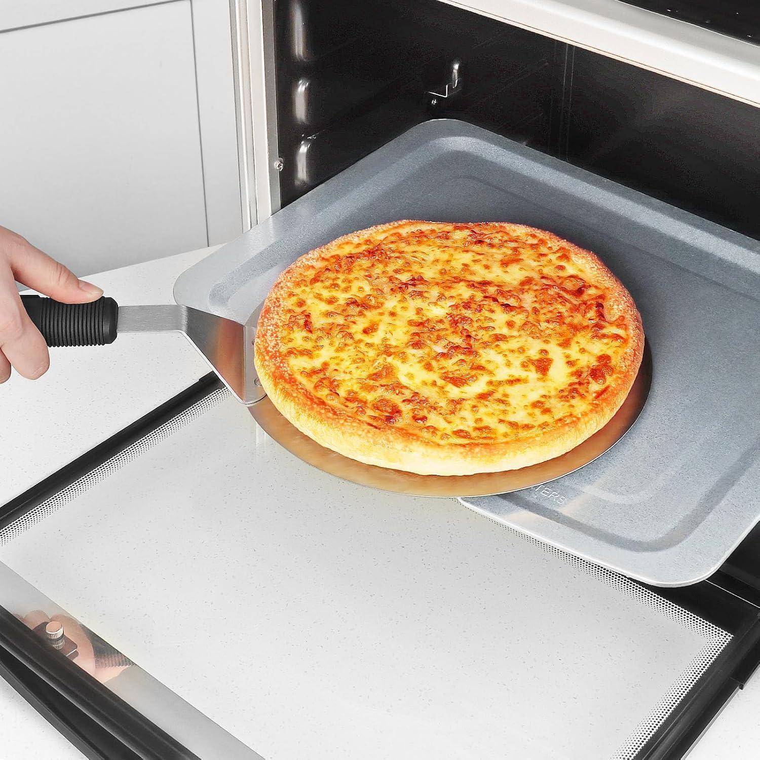 Eine frisch gebackene Pizza, die mit einer Metallpizzaschaufel aus dem Ofen geholt wird. Die Pizza ist goldbraun mit sichtbaren Käsebelägen.