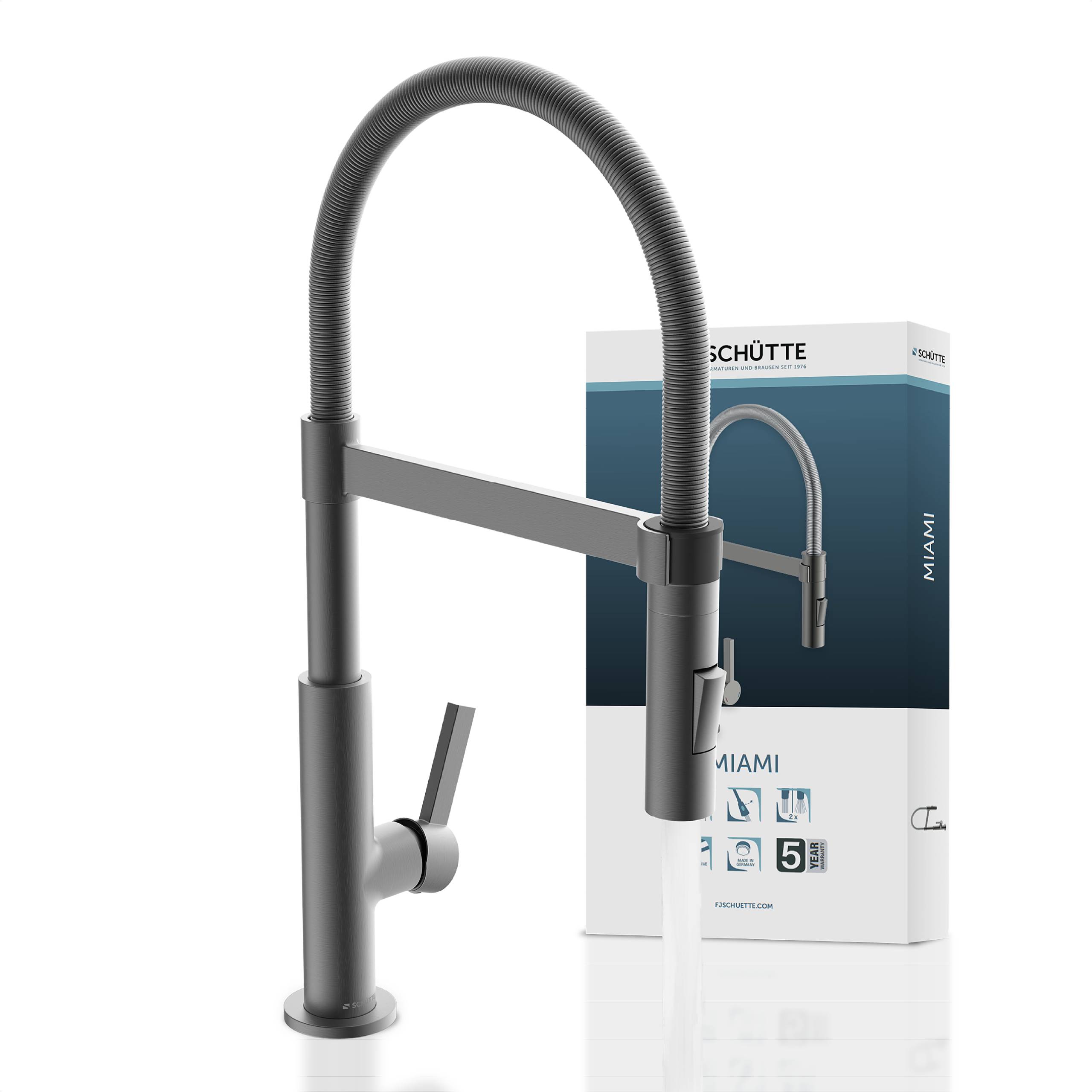 Ein verchromter Duscharmatur an einer grauen gefliesten Wand montiert, mit einem einhebel-Griff und einem flexiblen Schlauchansatz.