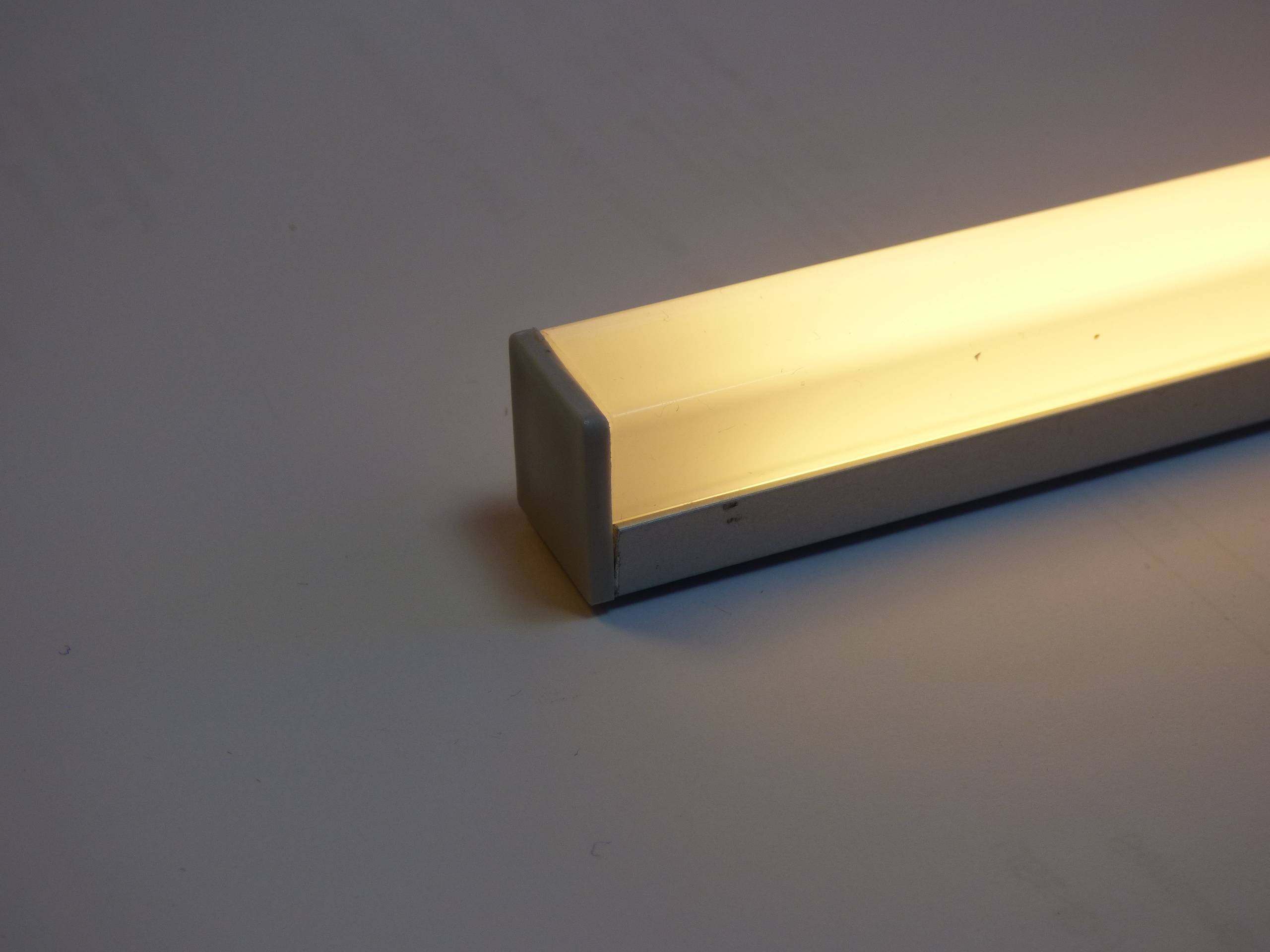 Eine rechteckige Leuchte mit minimalistischem Design verbreitet ein warmes, ambientes Licht.