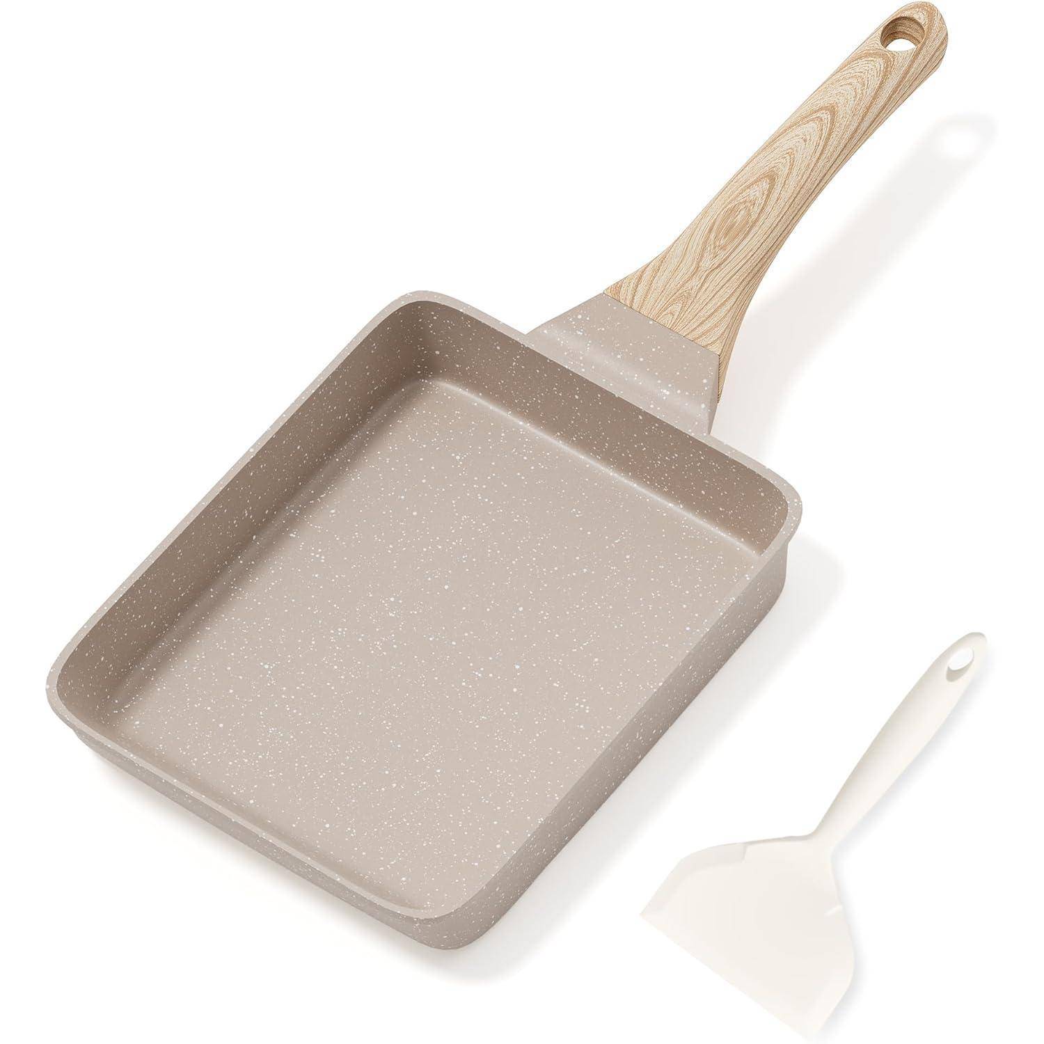 Eine beige, quadratische Bratpfanne mit einem holzmaserungsartigen Griff wird neben einem passenden weißen Pfannenwender gezeigt.