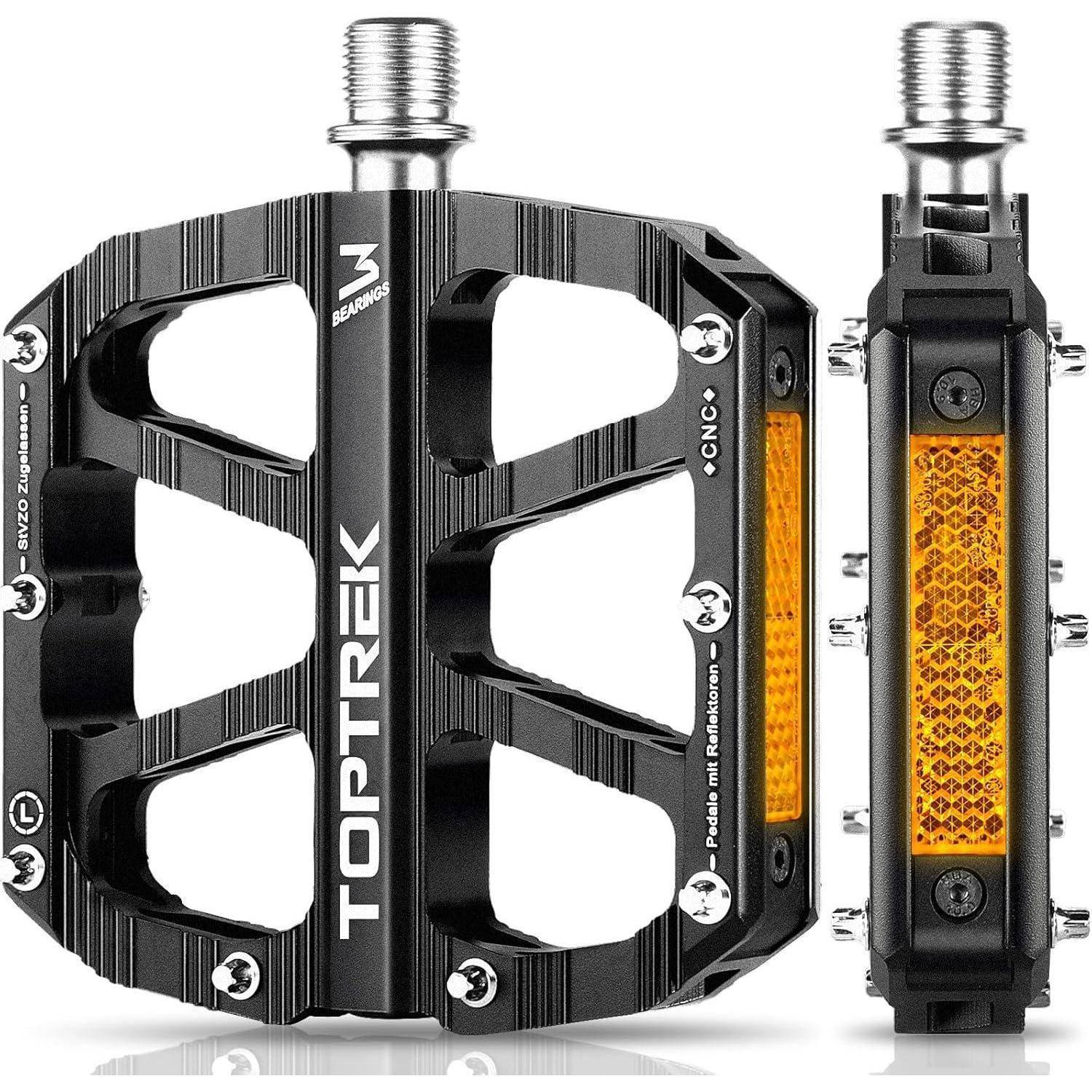 Ein schwarzes Mountainbike-Pedal mit Metallstiften und einem orangefarbenen Reflektor, der Marke 'TOPTREK', entwickelt für verbesserten Halt und Sichtbarkeit.