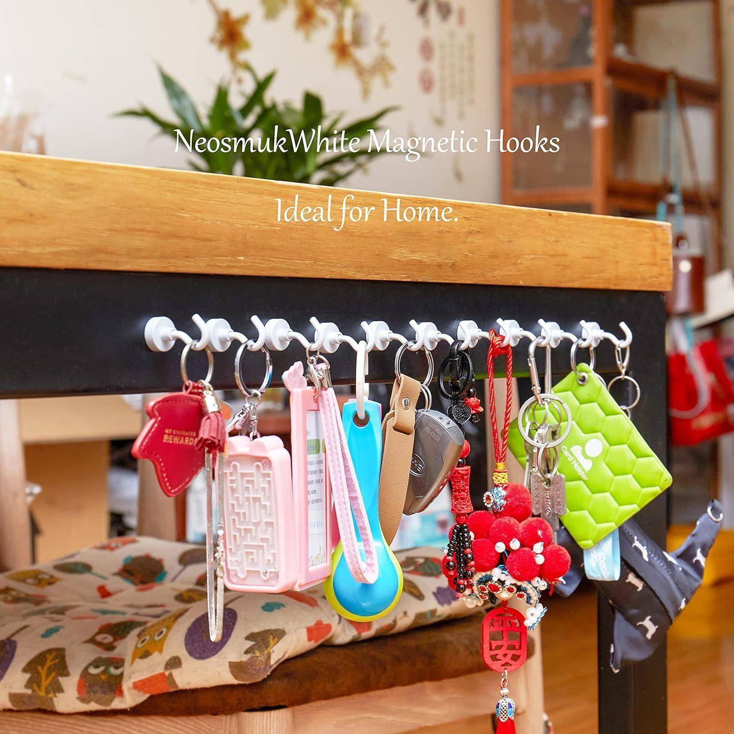 Magnetische Haken an einem Holzschreibtisch halten bunte Schlüsselanhänger und Accessoires und zeigen dabei eine Organisationslösung für den Heimgebrauch.