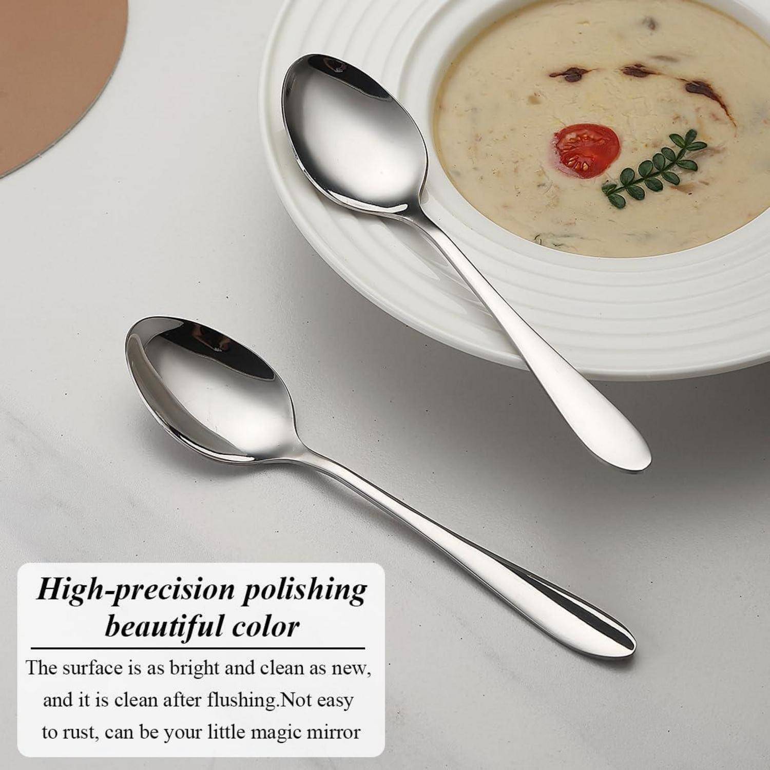 Zwei polierte silberne Löffel neben einer Schüssel mit cremiger Suppe, garniert mit Kräutern und Tomate. Text lautet: „Hochpräzises Polieren, wunderschöne Farbe.