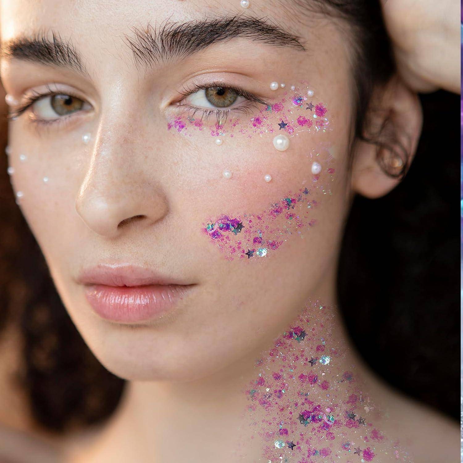 Eine Person mit lockigem Haar ist mit dekorativen Perlen und Blumen-Make-up im Gesicht geschmückt, vor einem unscharfen Hintergrund.