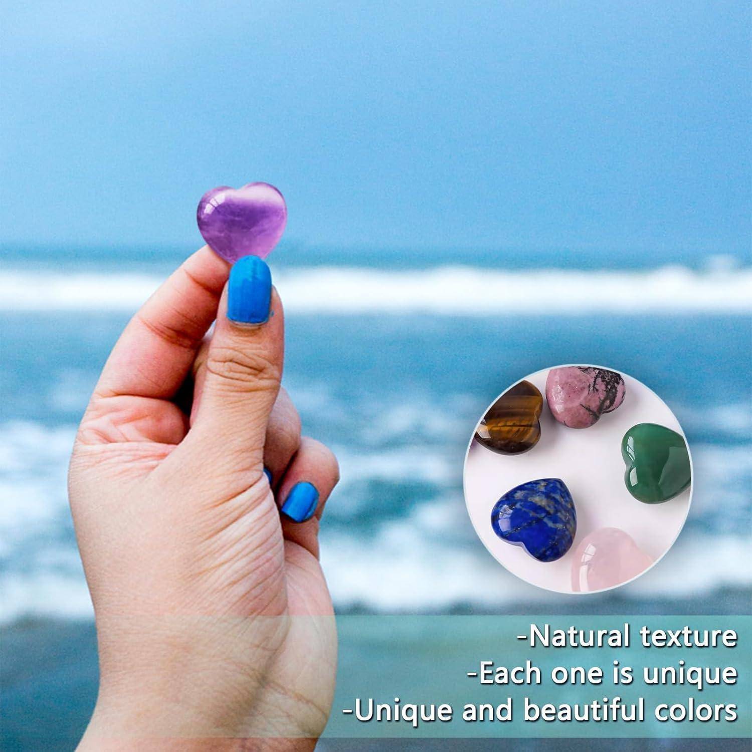 Eine Hand mit blauen Nägeln hält einen violetten herzförmigen Stein am Meer. Eingeblendet sind verschiedene Steine. Der Text lautet: „Einzigartige und wunderschöne Farben.