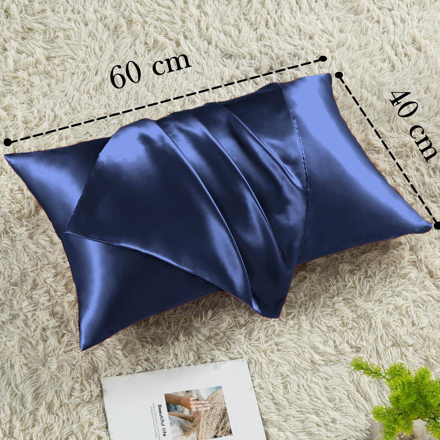Ein glänzender blauer Kissenbezug mit Origami-Design auf einem beigen Teppich, beschriftet mit '60 cm' und '40 cm'. Eine Zeitschrift ist in der Ecke teilweise zu sehen.