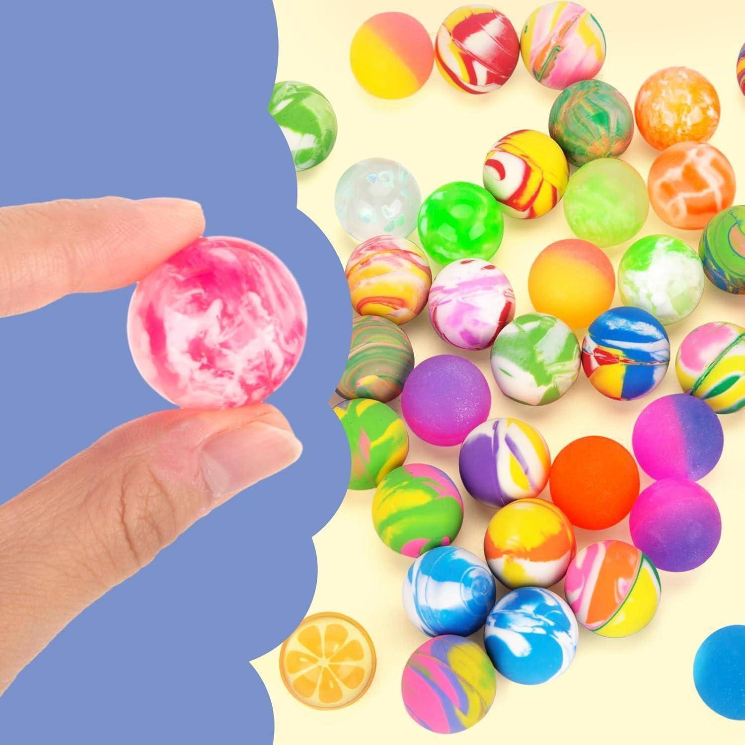 Eine Hand hält einen rosa-weißen Flummi vor einem Hintergrund verschiedenfarbiger Flummis, die auf einer gelben Oberfläche verstreut sind.