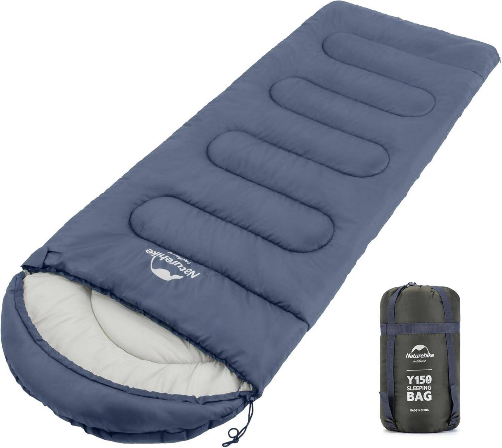 Blauer Schlafsack mit Logo und Text 'Naturehike' und 'Y15 Schlafsack' darauf. Eine passende kompakte Tragetasche liegt neben dem Schlafsack.