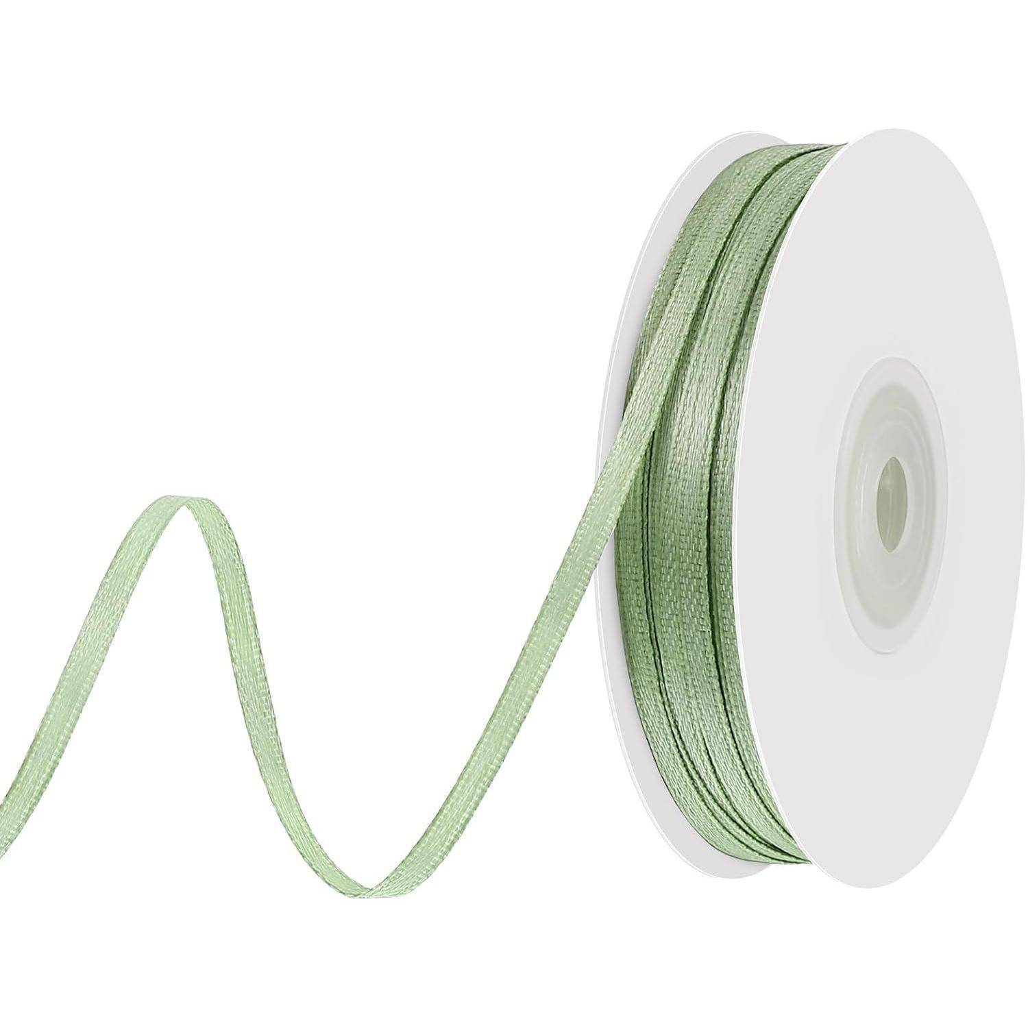 Eine Rolle hellgrünen Bandes rollt sich anmutig ab und deutet Eleganz sowie potenzielle Verwendung beim Basteln oder Geschenkeverpacken an.