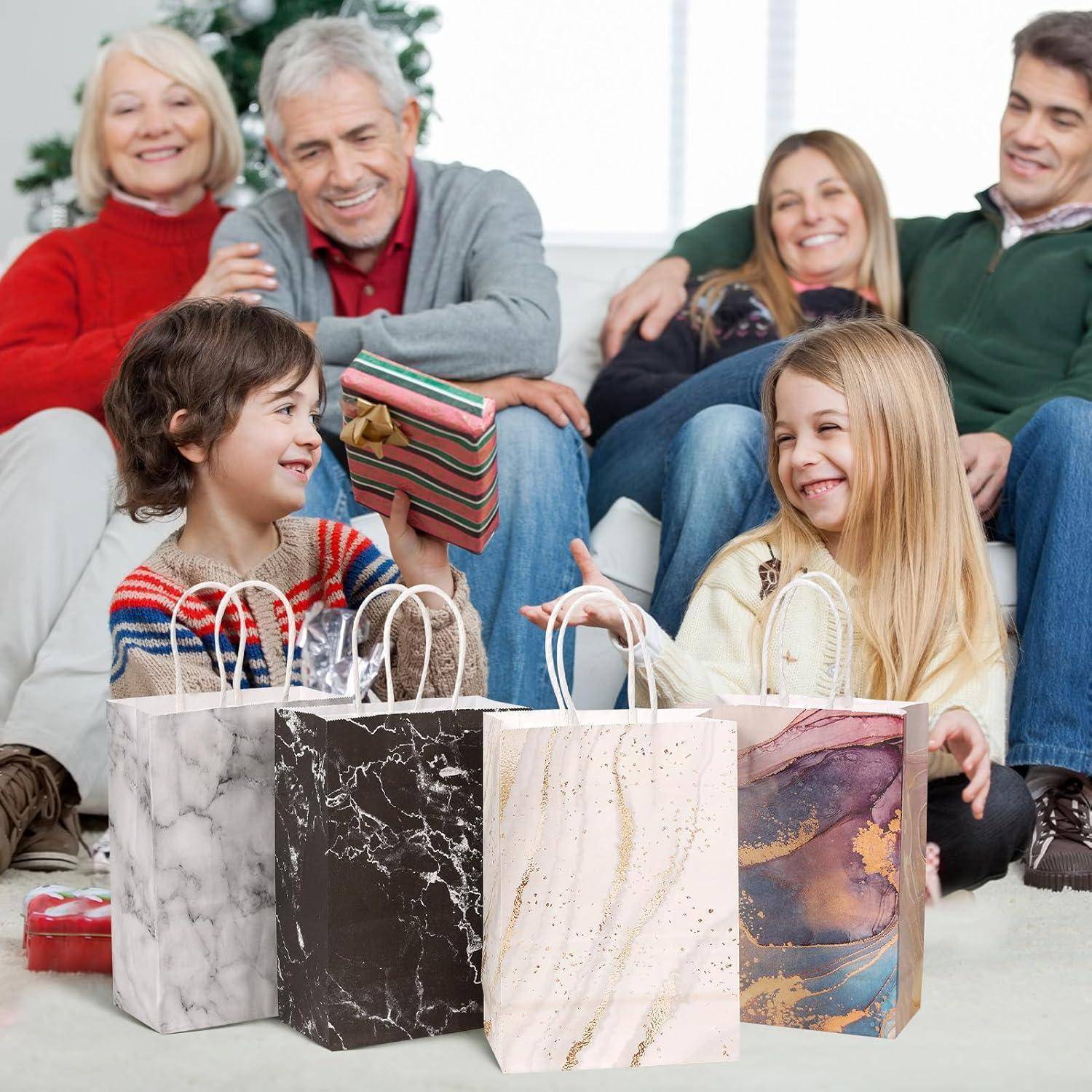 Eine Familie sitzt zusammen, lächelnd, um einen Weihnachtsbaum. Zwei kleine Kinder tauschen Geschenke aus, umgeben von dekorativen Geschenktüten.