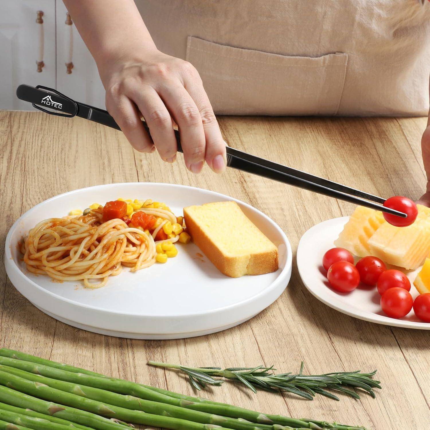 Eine Person, die Käse schneidet, neben einem Teller mit Spaghetti, Mais und einem Kuchenstück, mit Kirschtomaten an der Seite, in einer Küchenumgebung.
