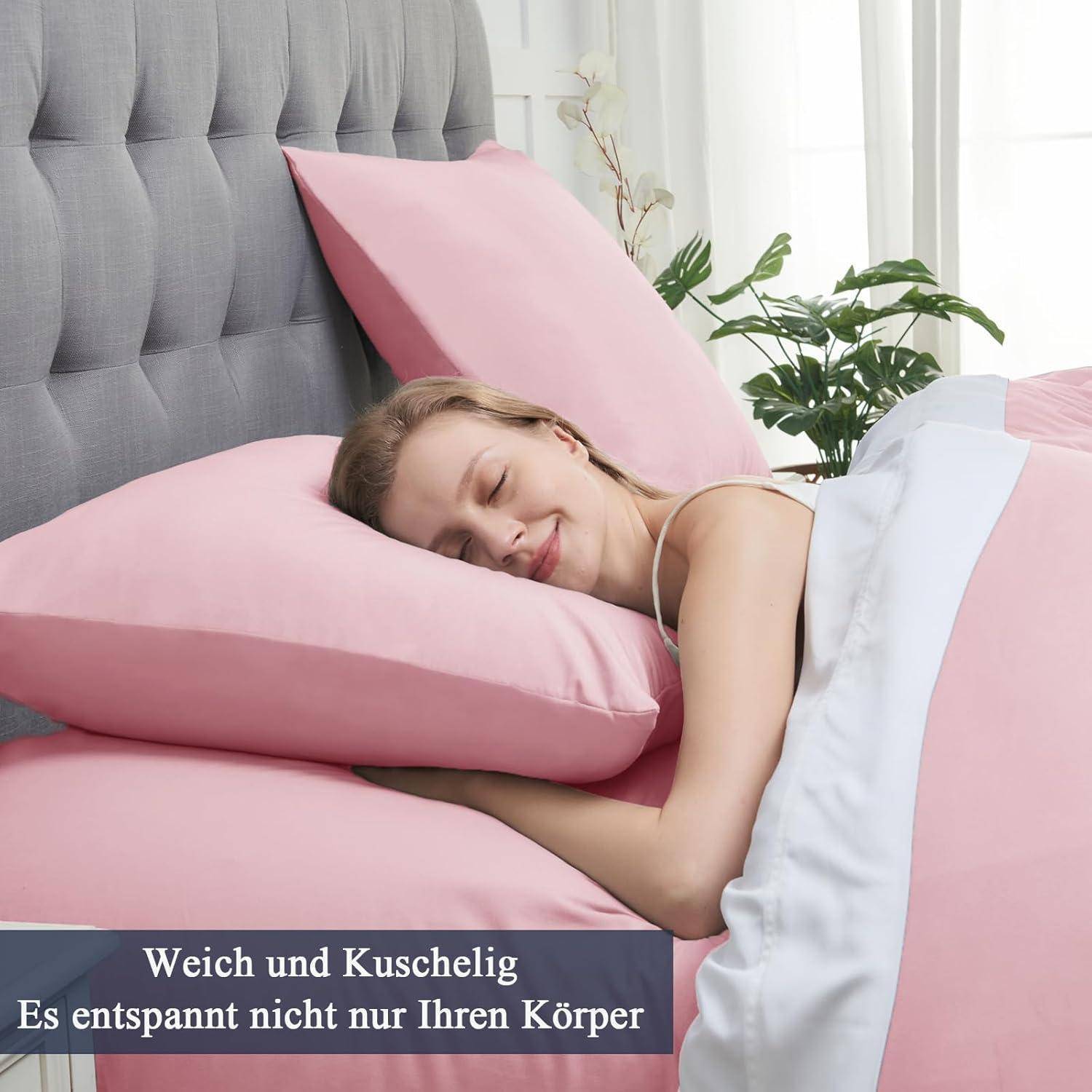 Eine Person, die friedlich auf einem Bett mit rosa Kissen und einem grauen Kopfteil schläft. Text lautet: 