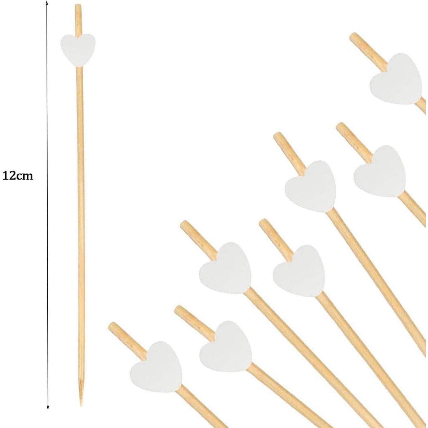 Spieße mit weißen herzförmigen Oberteilen. Jeder Spieß ist 12 cm lang. Sieben Spieße sind diagonal angeordnet.