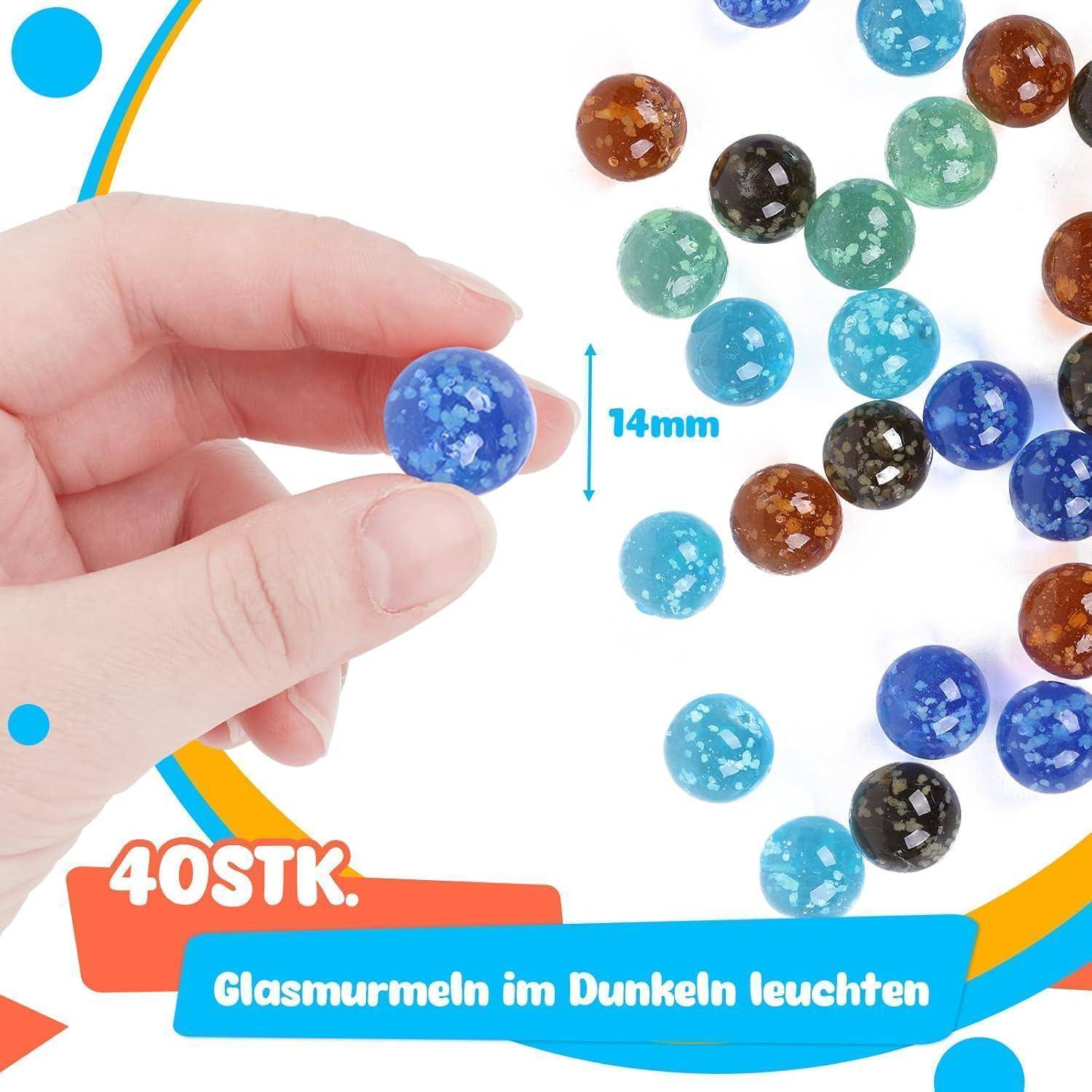 Eine Hand hält eine blaue Glasmurmeln; 17 Murmeln in verschiedenen Farben und Größen gezeigt, mit der Beschriftung 14 mm, mit dem Text: '40 Stk.' und 'Glasmurmeln im Dunkeln leuchten'.