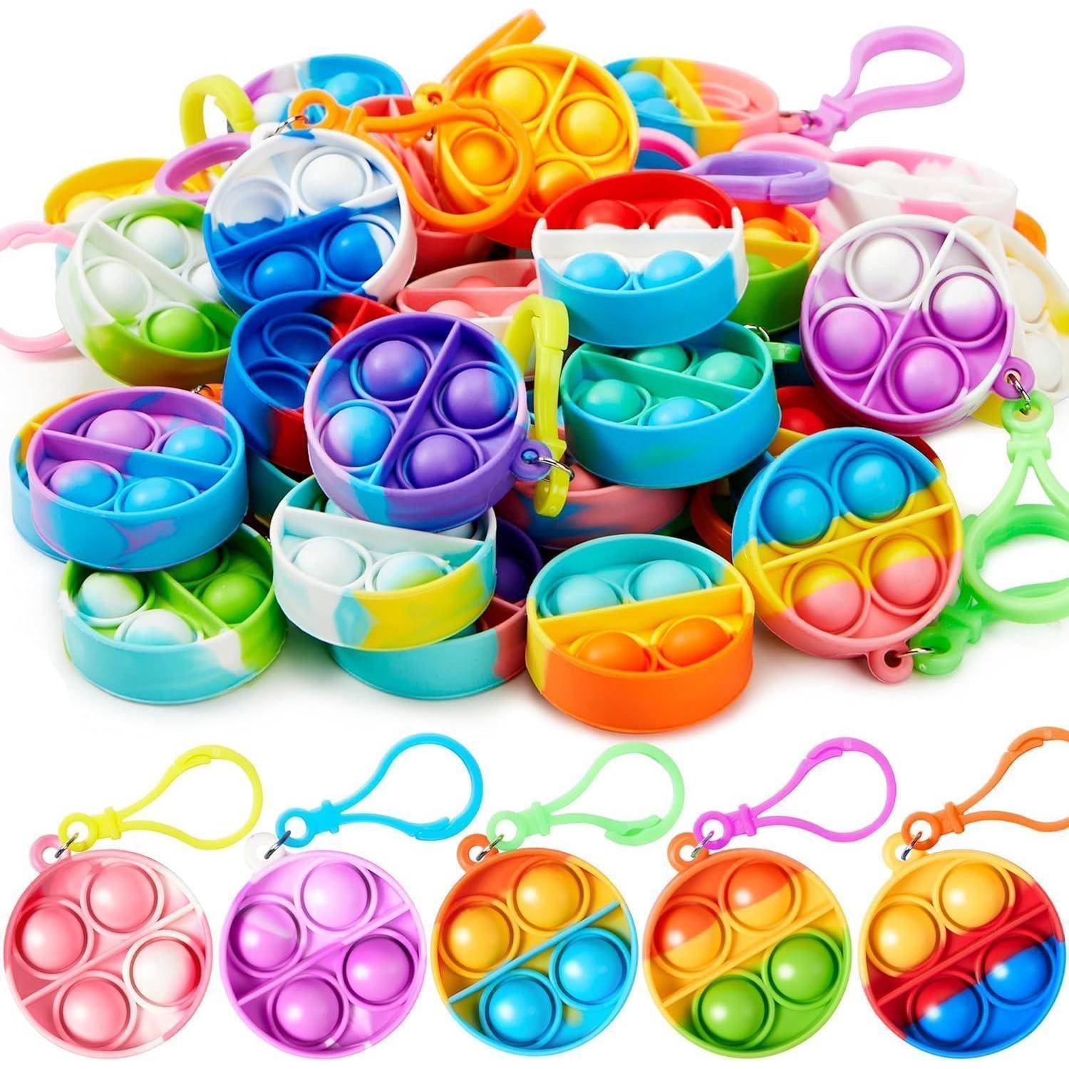 Eine Sammlung bunter Pop-Spielzeuge mit verschiedenen Designs und Schlüsselanhängern, die jeweils mehrere blasenähnliche Vertiefungen zum Herausdrücken besitzen.