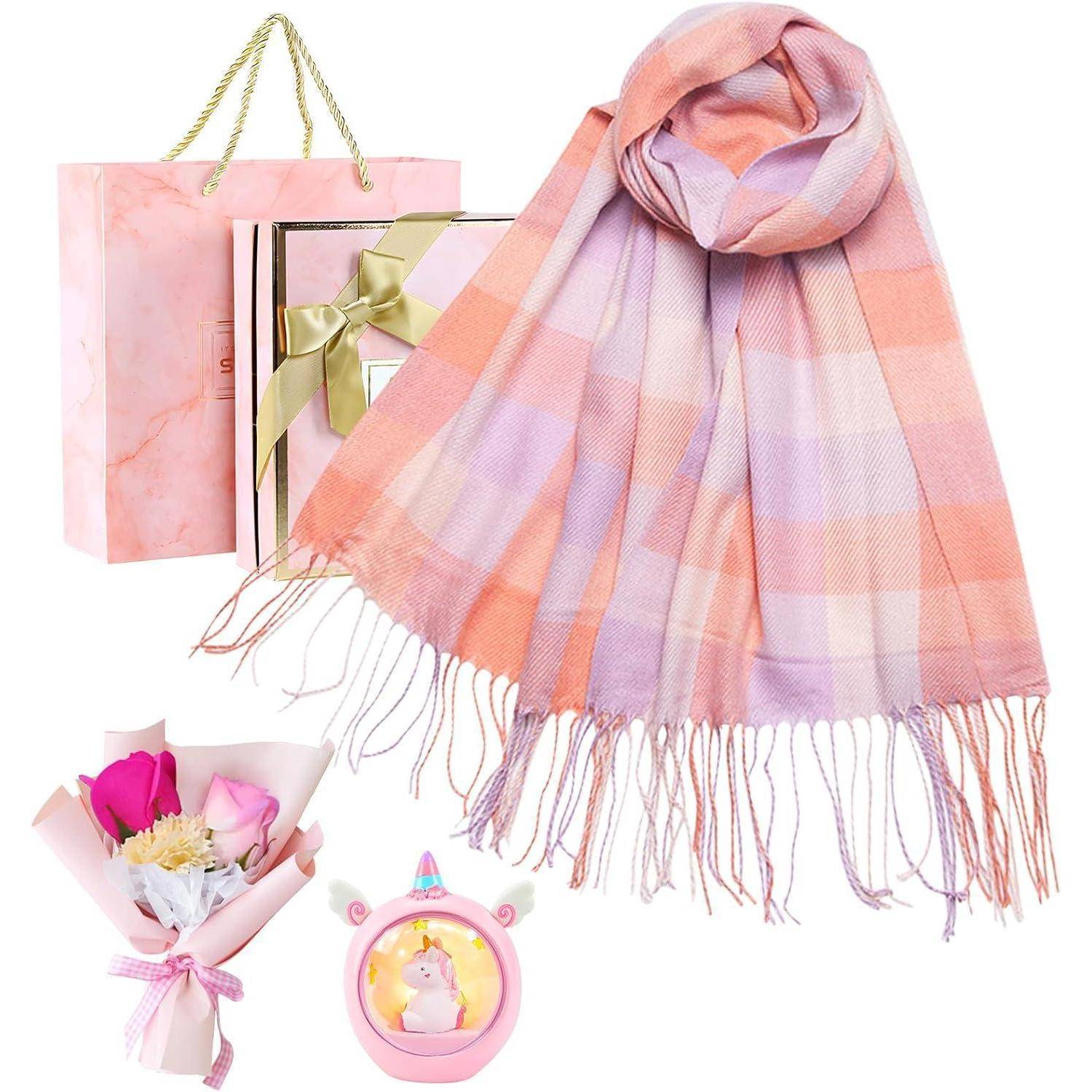 Ein rosa Geschenkset mit einem Karoschal, einem Blumenstrauß, einer Einhorn-Tasse und einer Geschenktüte, ideal für besondere Anlässe.